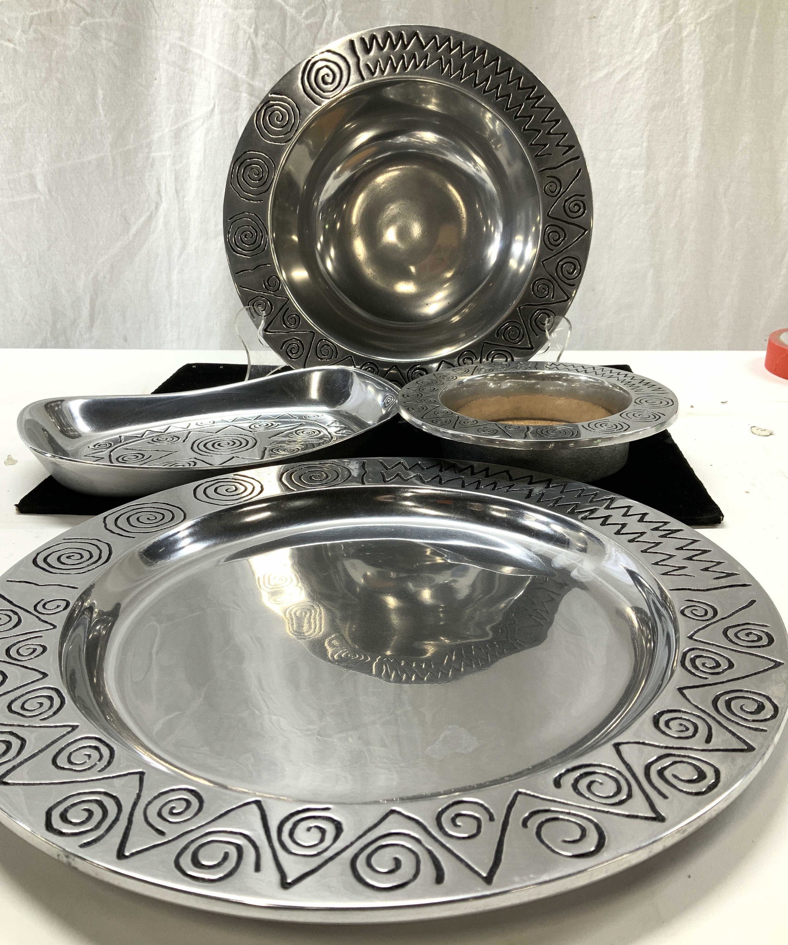 Set 4 Wilton Armetale Southwestern Style Metalware: New in package/ boxes. Metal tableware accessories, etched southwestern designer on silver tone polished finished , brushed metal on verso. Platter/ tray 12.25 in. Champagne bottle/ wine bottle coaste