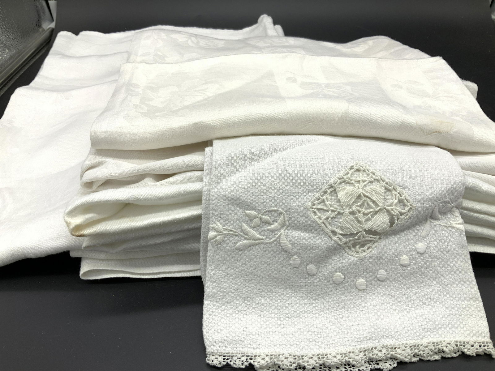 Lot 13 White Dinner Napkins and Hand Towels: White dinner napkins and hand towels, some include Irish linens, One large tea towel is monogrammed M & H, measures 32 x 28 in. Various fabrics- linen, nylon/acetate, cotton. Wear and condition issues