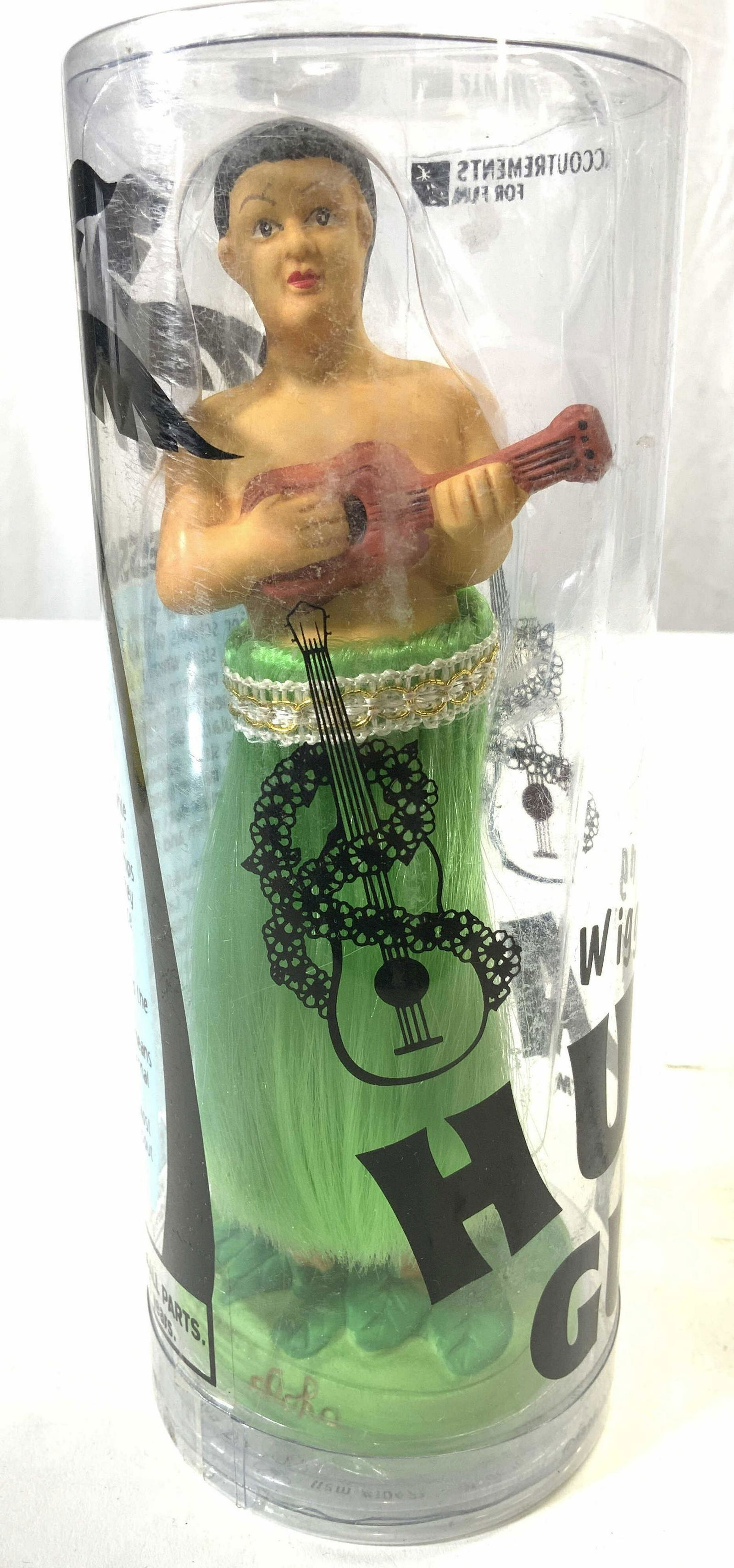 ACCOUTREMENTS Wiggling Hula Guy NIB: Box reads ACCOUTREMENTS WIGGLING HULA GUY. Piece shows male figure with hula skirt & ukulele. Base reads ALOHA. Box measures approx 7.75 inches tall 3 inches wide. Accoutrements, accoutrements hula gu