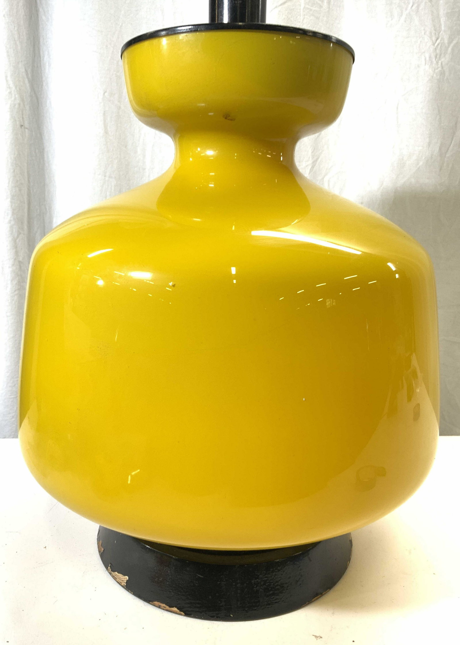 Opaline Glass Table Lamp In Yellow: Lamp is yellow toned appears to be opaline glass. Base is circular toned, appears to be lacquered wood. Measures approx 35 inches tall 16 inches wide. Lamp, table lamp, side table lamp, end table lamp