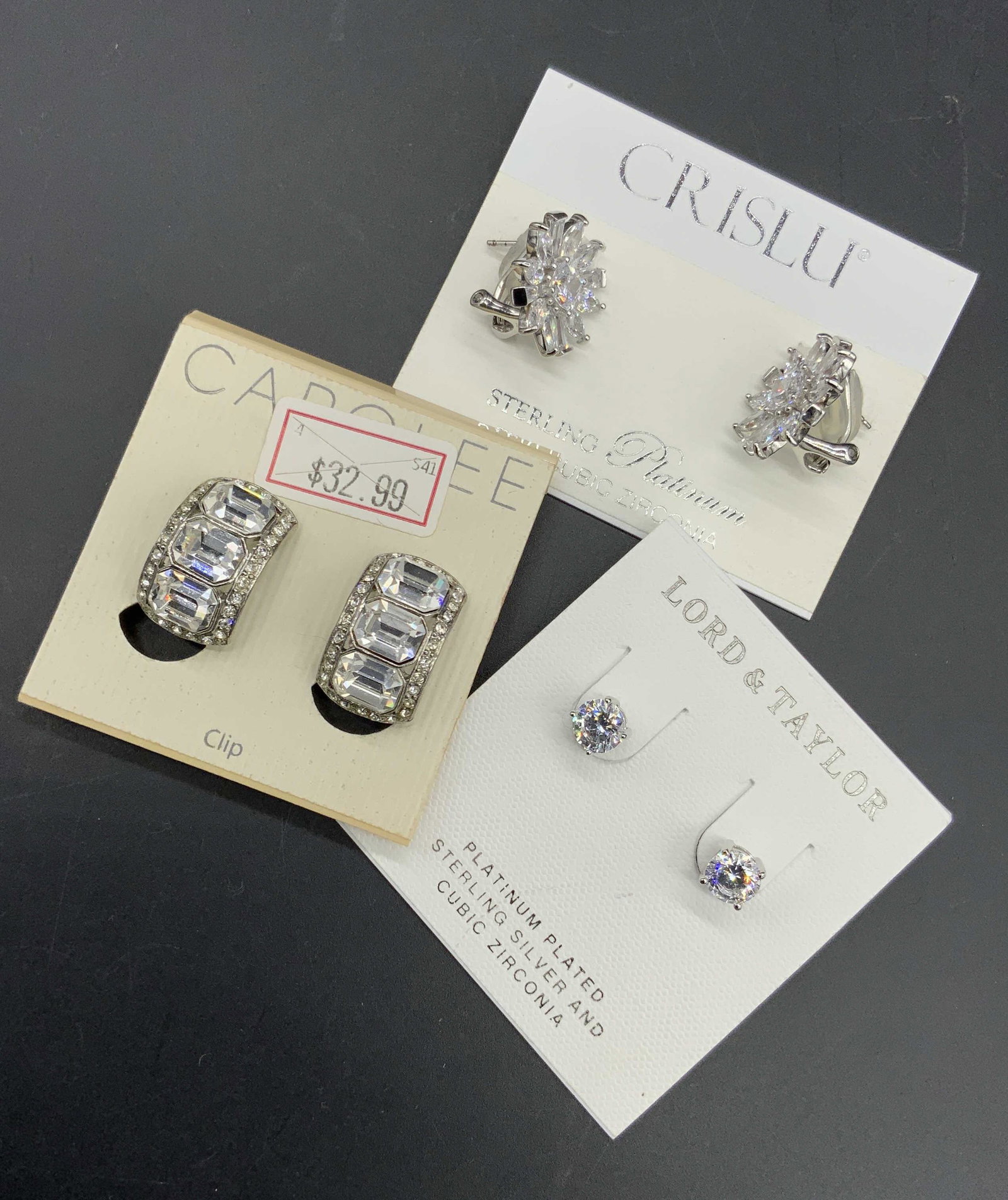 Set 3 Earrings Sterling CRISLU LORD&TAYLOR CAROLEE: All pieces affixed to their original packaging. CAROLEE, LORD&TAYLOR, and CRISLU. The CRISLU earrings are sterling platinum cubic zirconia as indicated by the packaging. Reverse of packaging reads ori