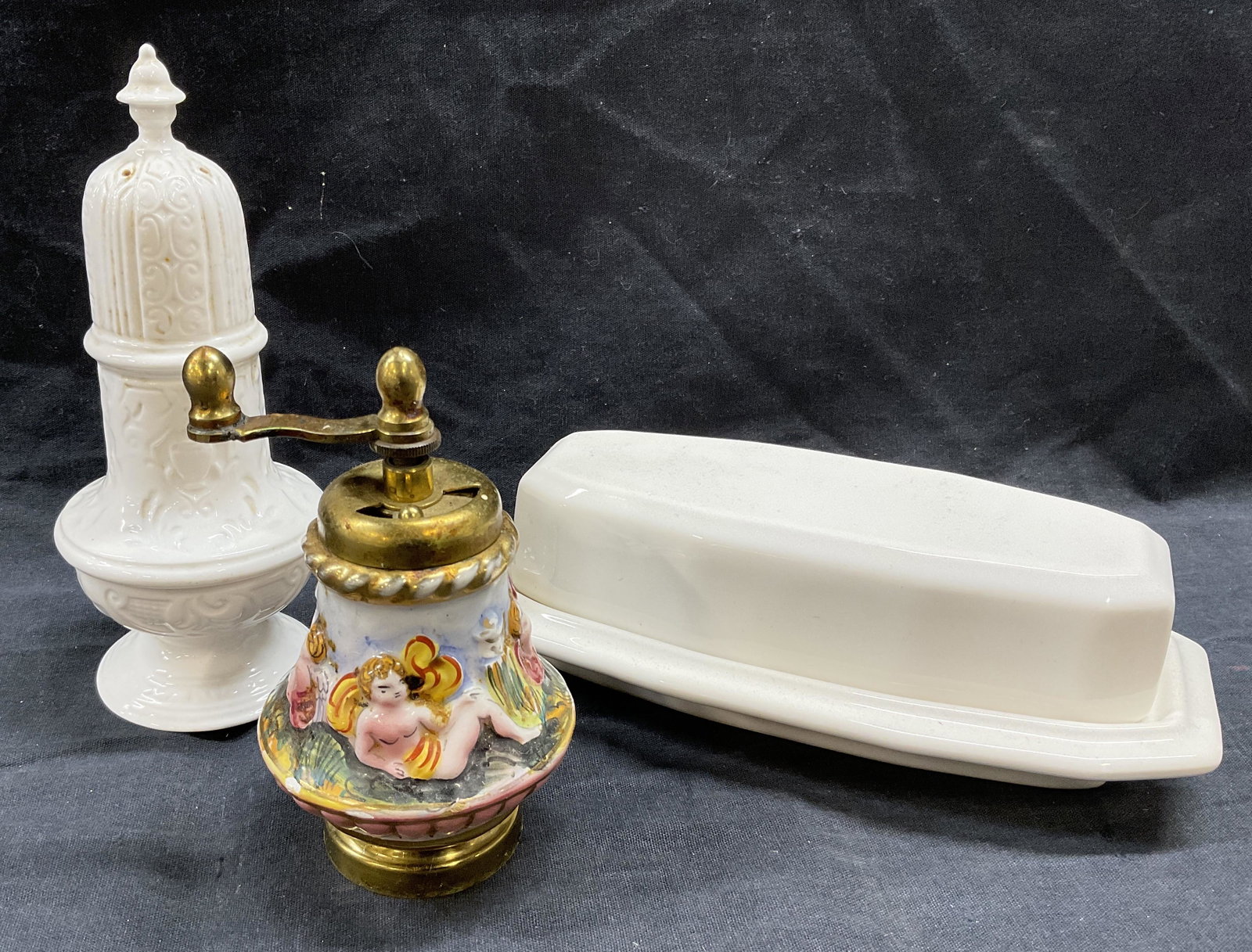 Lot 3 Tabletop Wares, Butter Dish & More: Lot 3 Tabletop Wares. Surrey Collection Salt Shaker, Fine bone China Staffordshire England. Pepper Grinder with putti figural reliefs to exterior. White porcelain butter dish, illegible signing on bot
