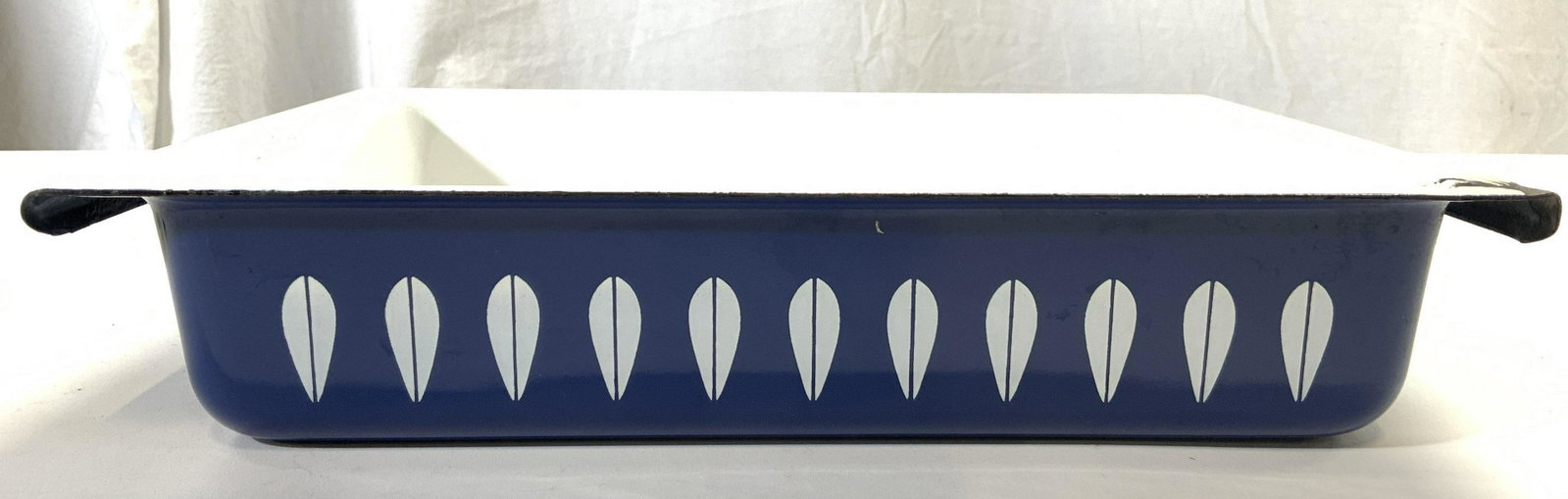 CATHERINEHOLM NORWAY Enamelware Casserole Dish: Underside is marked MADE BY CATHERINEHOLM NORWAY. Piece is metal enamelware. Interior is white, exterior is blue toned with white geometric pattern detail. Piece measures approx 13.5 inches long 9.5 i