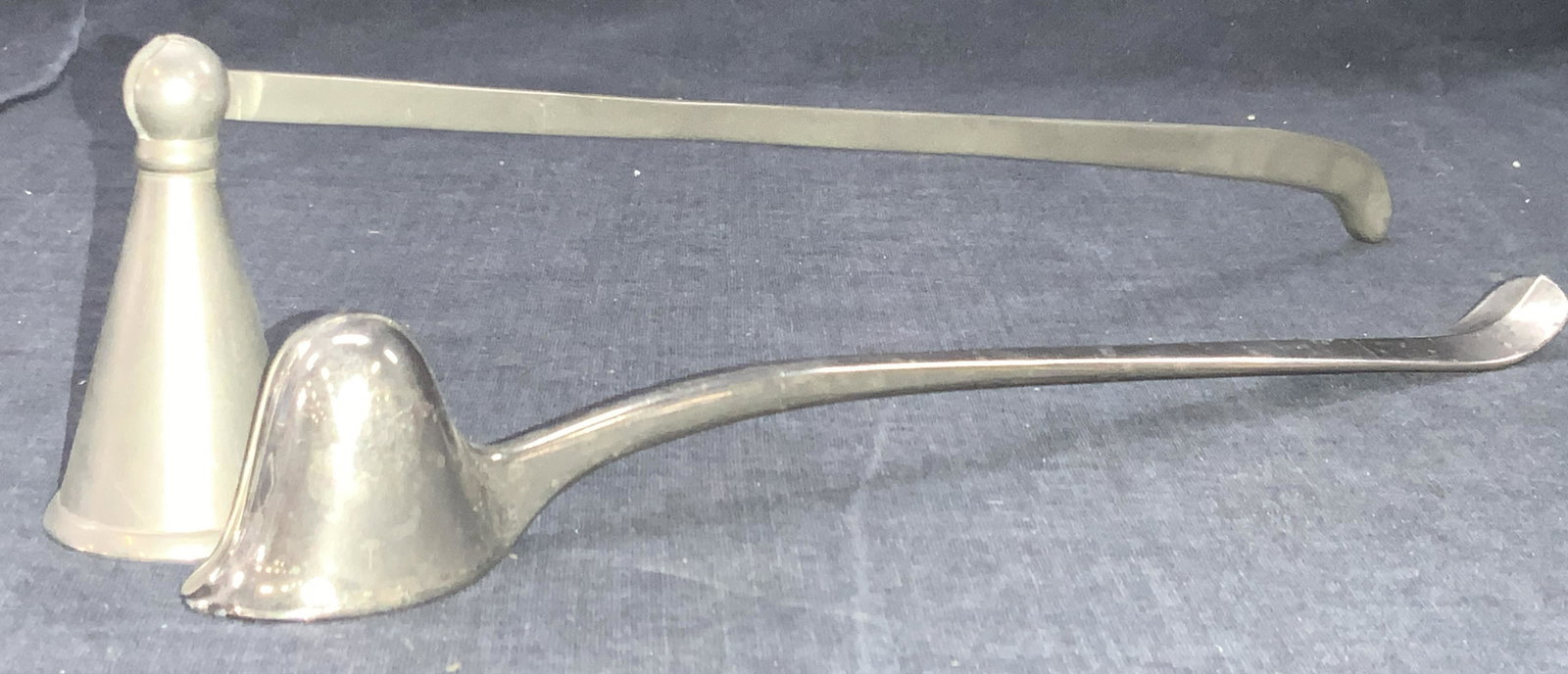 Lot 2 Vintage White Metal Candle Snuffers: 2 vintage white metal candle snuffers, 1 with a hinge marked made in India, and 1 without marked Made in Italy. 1 approximately 10 inches long and 1 benign approximately 13 inches long. Minor wearing 
