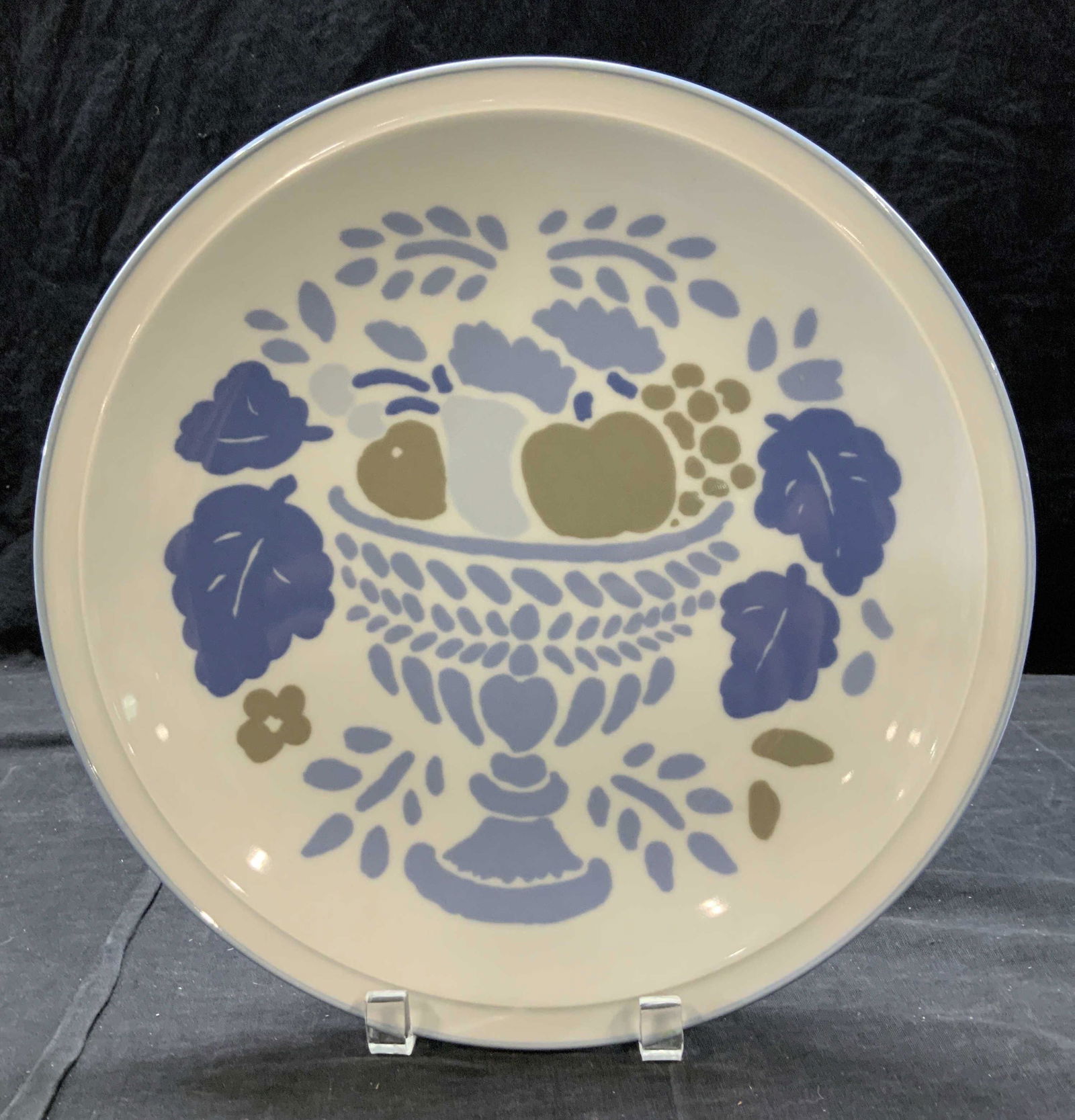 DANSK FOOTED PORCELAIN PLATE, JAPAN: Hand painted porcelain plate depicting urn with fruit. Meant to display in wall ( wire holes are on verso) but can be used to serving. Plate is white with stencil style patterns in blue and taupe. Pla