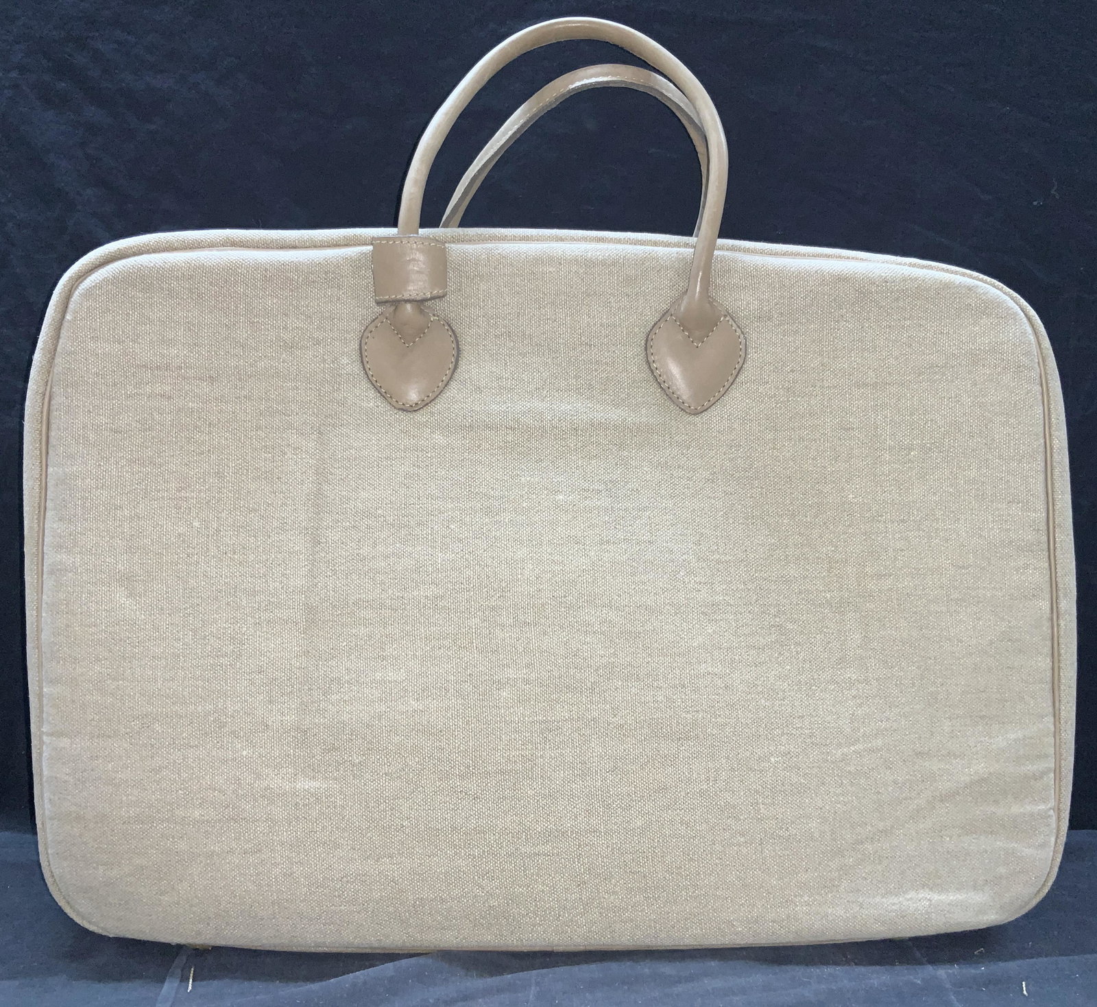 Martha Stewart Canvas Suit Case: A canvas zipper suit case with top handle. Comes with attachable shoulder strap. Comes with name tag marked Stewart. Approximately 23 x 7 x 17 inches. Wearing to underside. Property of Martha Stewarts
