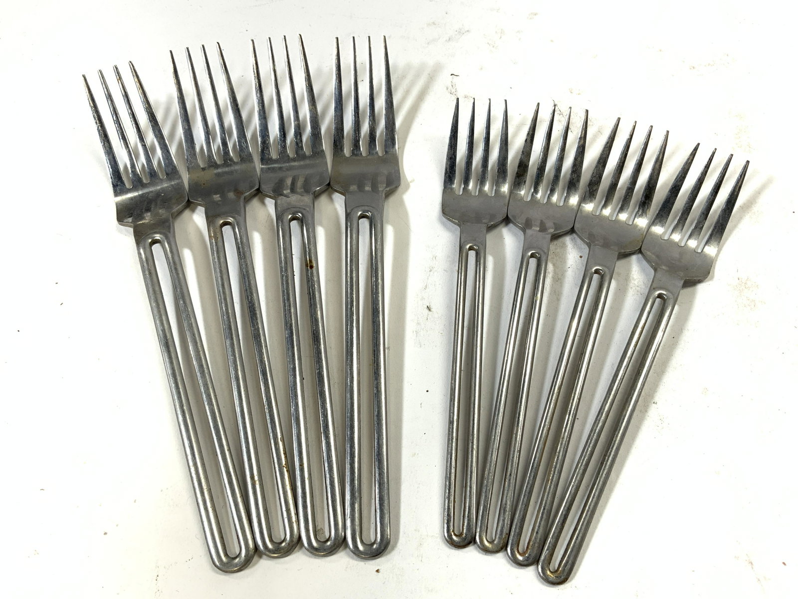 THE CELLAR Lot 8 Stainless Steel Forks: Each fork is inscribed THE CELLAR. Each fork is silver toned and stainless. Lot includes 4 larger forks & 4 smaller forks. Largest forks measure approx 7.5 inches long. Forks, stainless forks, The Cel