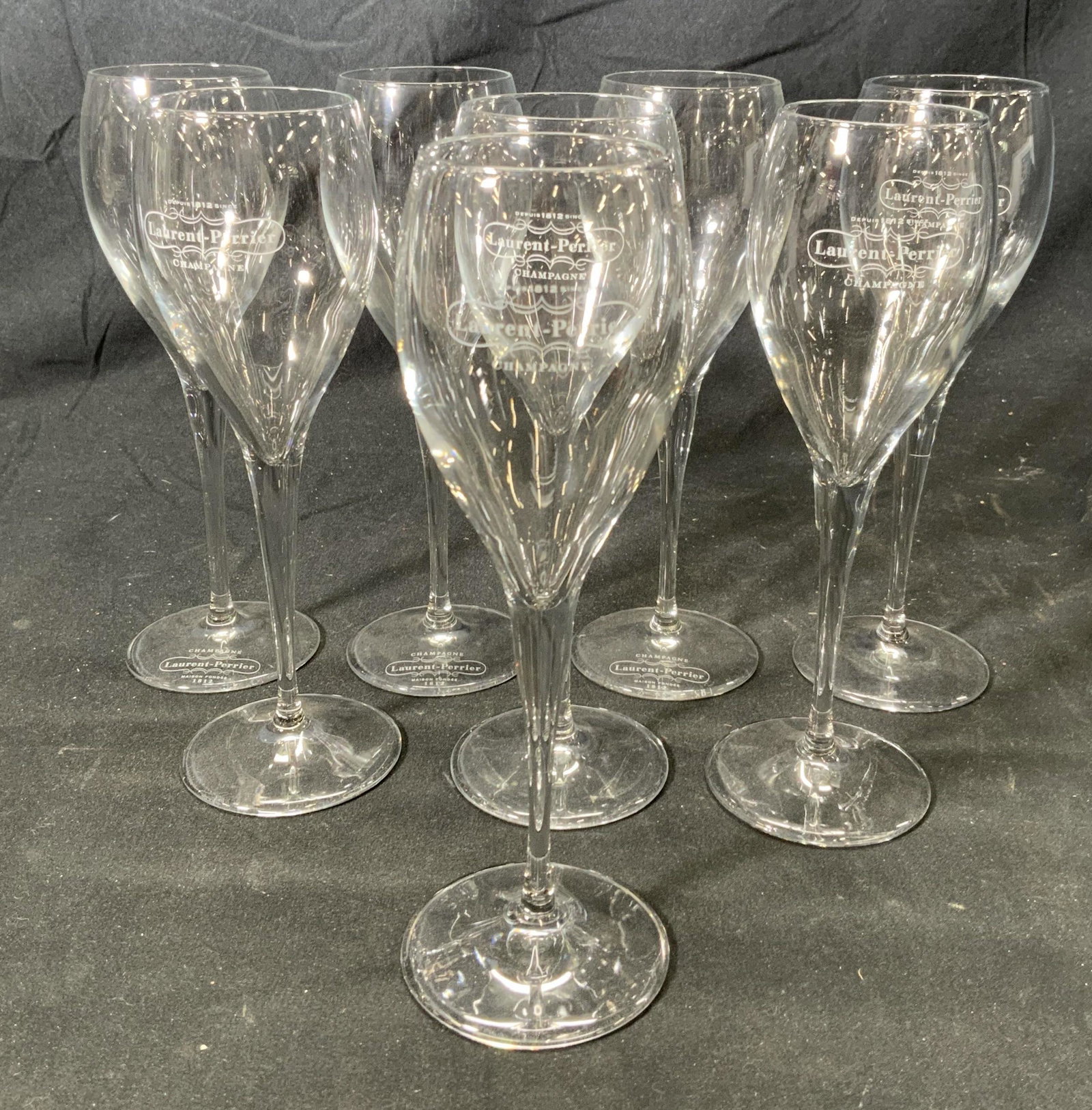 Set 8 LAURENT PERRIER Champagne Glasses: Set of 8 Laurent Perrier champagne glasses. 3 glasses signed to bases and 5 glasses signed to bodies. Measure approx. 2.5 inches diameter and 7.75 inches tall each. Some surface wear consistent with e