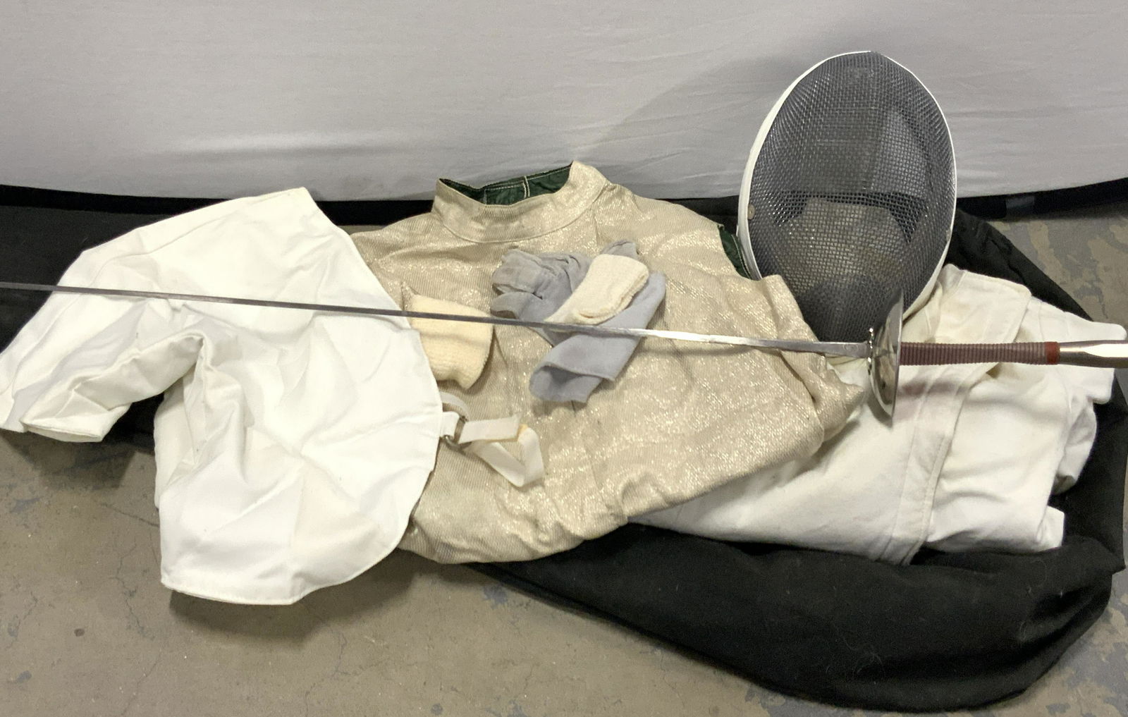 STANTELLI Fencing Equipment Bag & More: Fencing equipment bag marked STANTELLI on strap, in case is 1 Steel Fencing Sabre also marked Stanelli, handle is wrapped in red and white, approximately 43 inches long. 1 fencing mask, glove, jacket,