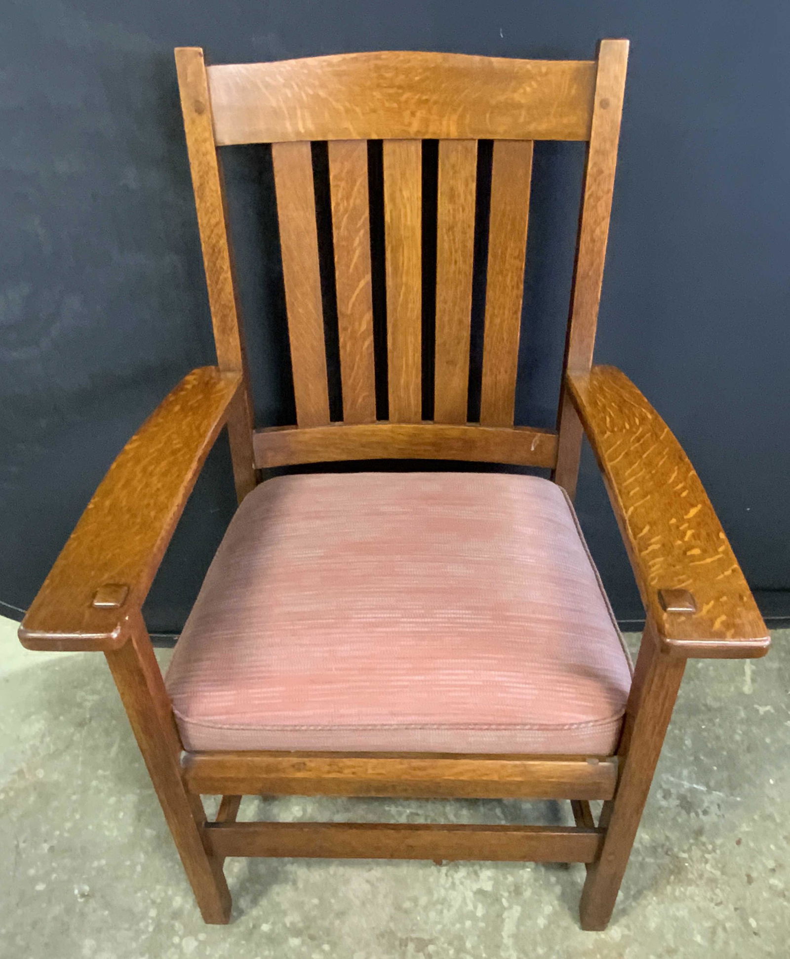 L & JG STICKLEY Mission Style Upholstered Armchair: A vintage wooden mission style armchair crafted by Stickley. Primarily red hued upholstered seat. Seat cushion is removable. Measures approx 38.5H x 26W x 20D inches. Label reads The Work of L & J.G S