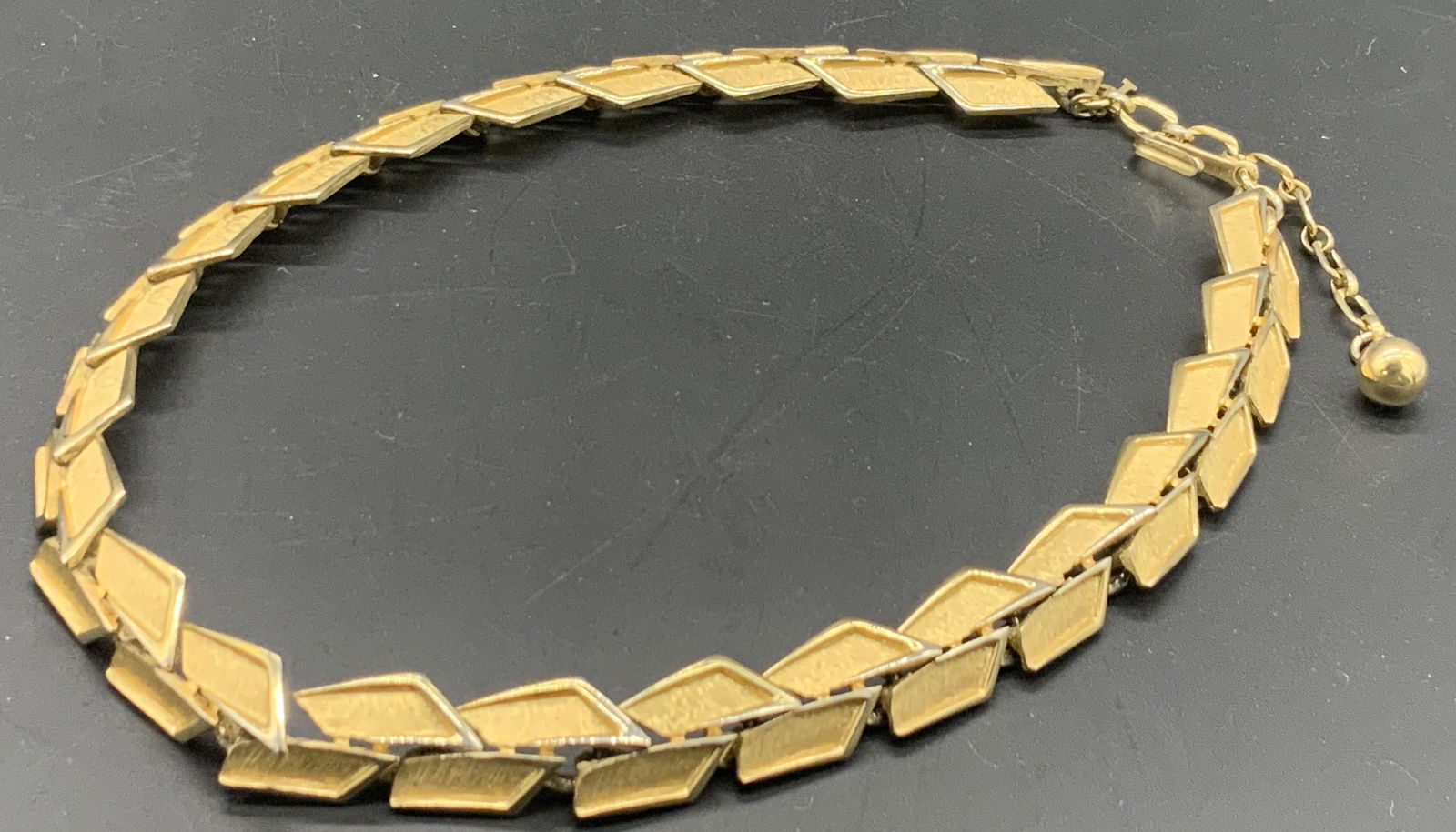 TRIFARI Vintage Geometric Panel Choker Necklace: Vintage Geometric gold tone metal panel style choker necklace. Fishhook clasp closure marked TRIFARI. Necklace length approx 16 inches. Adjustable. Some surface wear consistent with use and age. Vinta