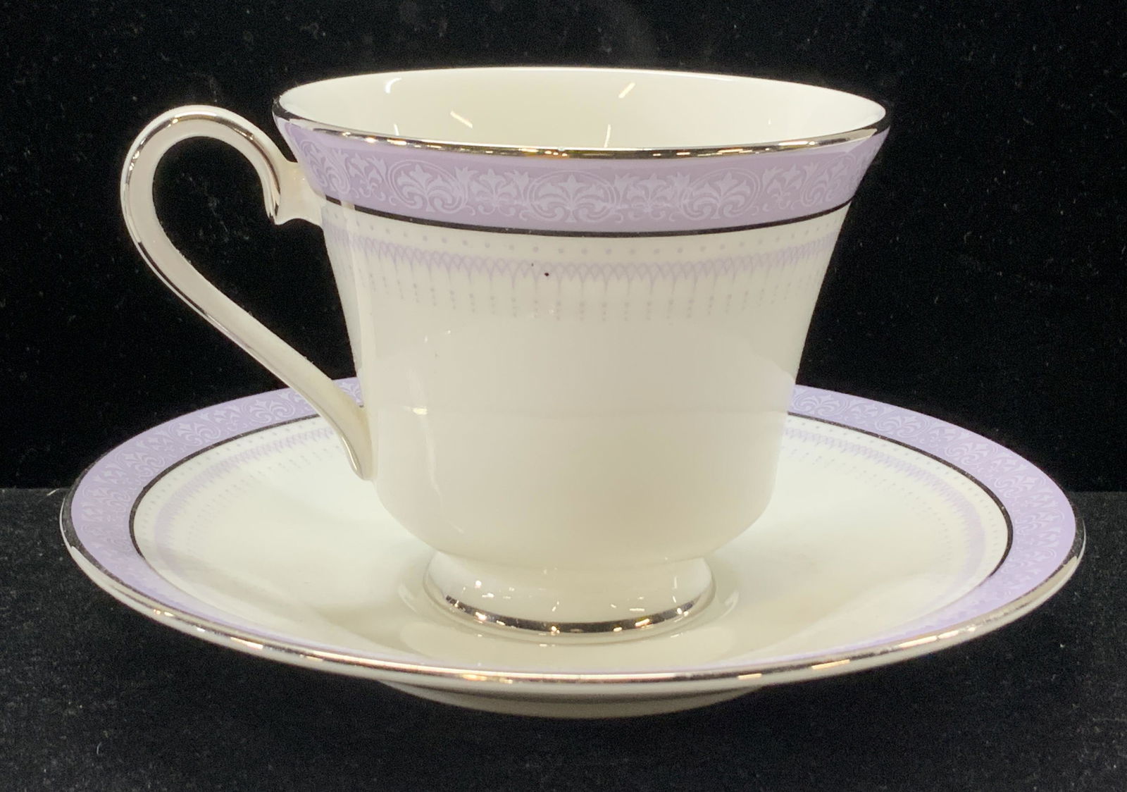 Royal Doulton Lilac Time English Bone China, 2 pc: White and lavender fine bone English China tea cup and saucer. Hallmarked Royal Doulton Lilac Time H. 5022 English Fine Bone China. Silver toned rims add to the calming colors. Saucer measures 6 in. C