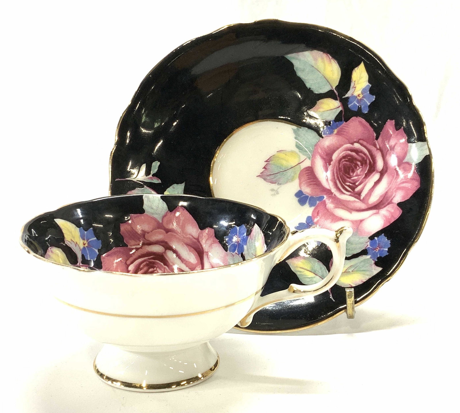 Paragon English China Cup & Saucer: Footed cup and saucer hand painted black with large pink rose on white fine bone China. Hallmarked Paragon England. This pattern is by appointment for H.M The Queen & HM The Queen Mary. Additional no 