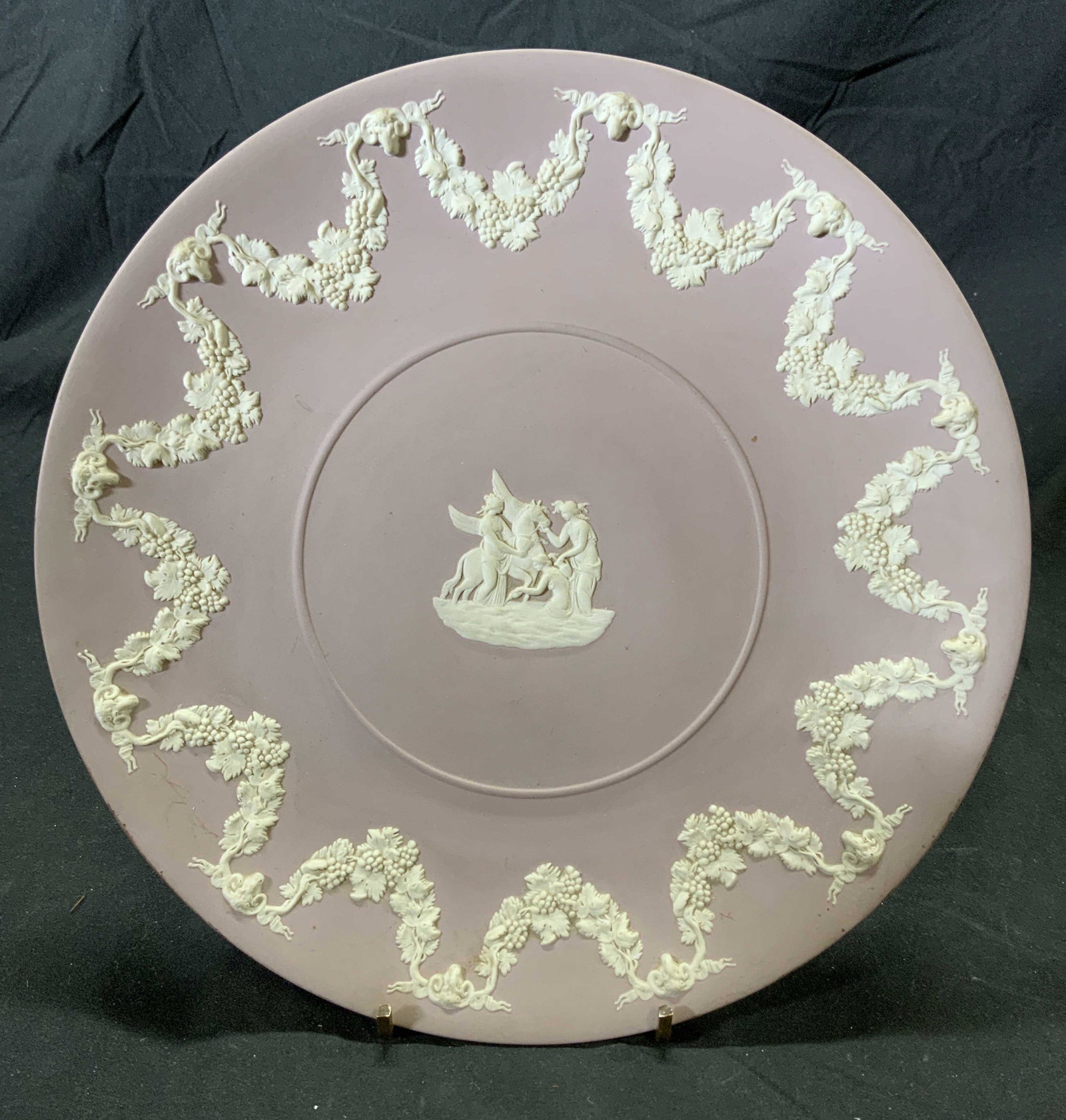 WEDGWOOD Vintage Plum Jasperware Plate: Vintage Wedgwood Jasperware plate in plum. White relief decoration with figural, Pegasus, and grapevine motif. Measures approx. 9.5 inches diameter. Some surface wear consistent with exposure. Tradema