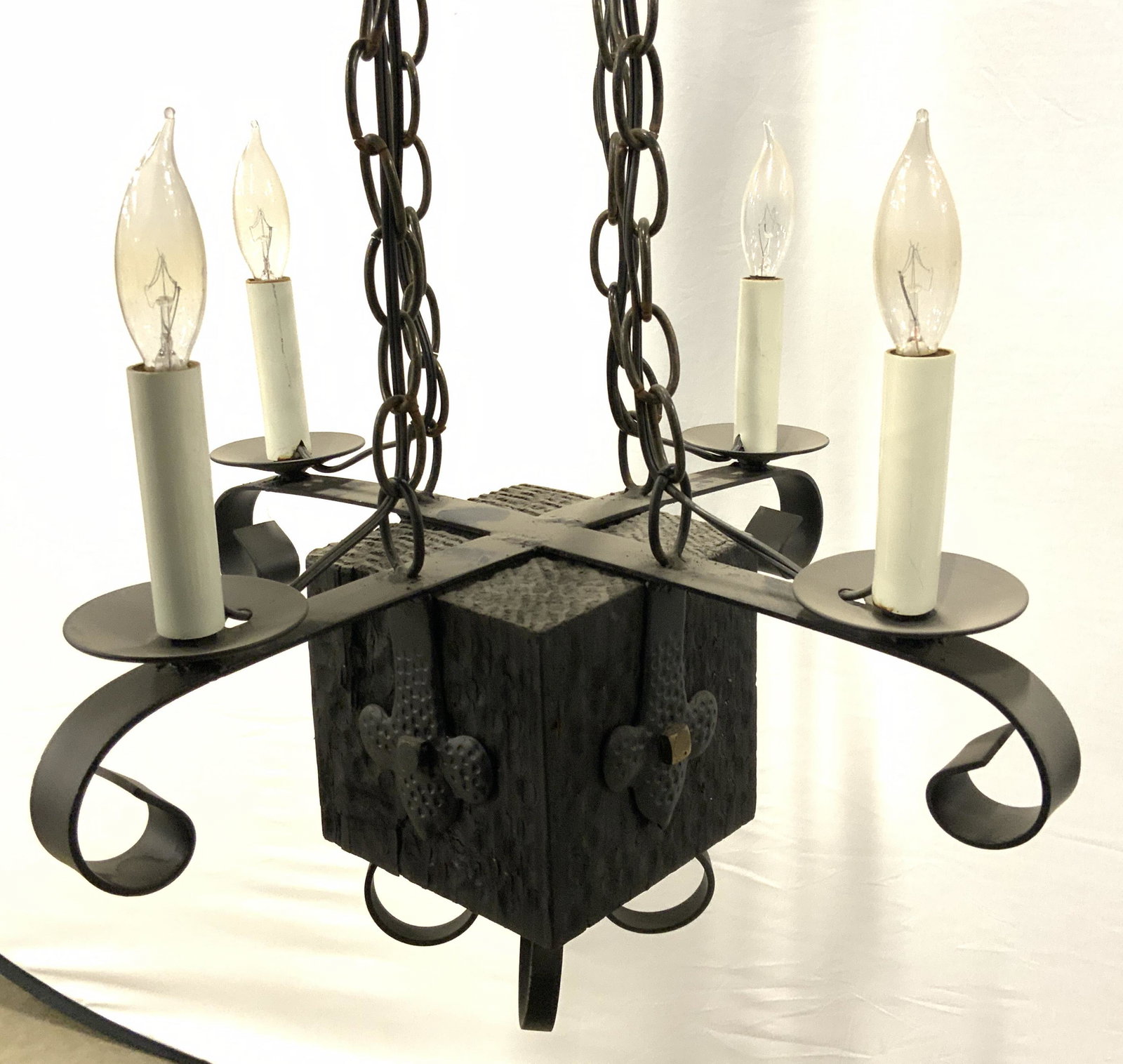 4 Arm Metal Candlestick Style Chandelier: Chandelier is metal. Piece has 4 arms, each with candlestick style bulb socket at ends. Base of piece has cube shaped structure. Piece measures approx 31 inches tall 17 inches wide. Chandelier, four a