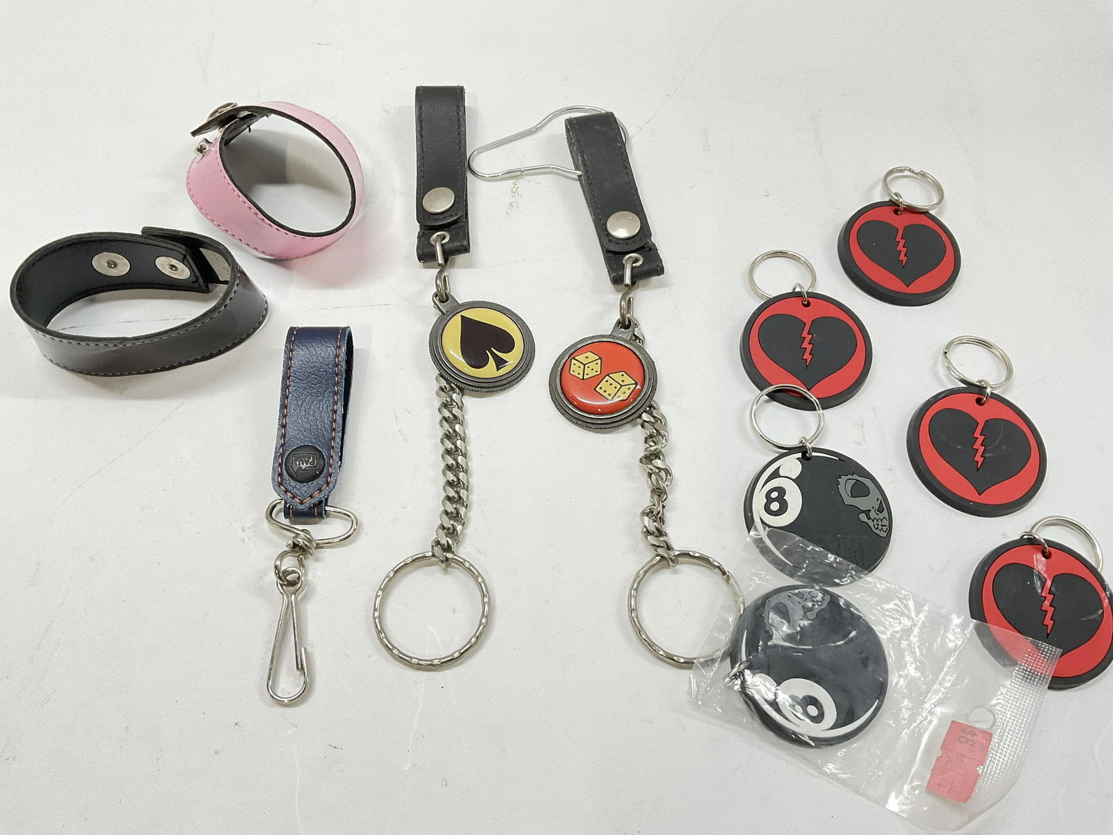 Lot 11 Key Chain, & Wearable Items: Lot 11 Key Chain, & Wearable Items. 2 cuffs, 2 keychains, which measures approx 9 inches. Smaller keychains read on back Emilys broken hearts club Copyright 2002. Key chains, heart keychains, dice key