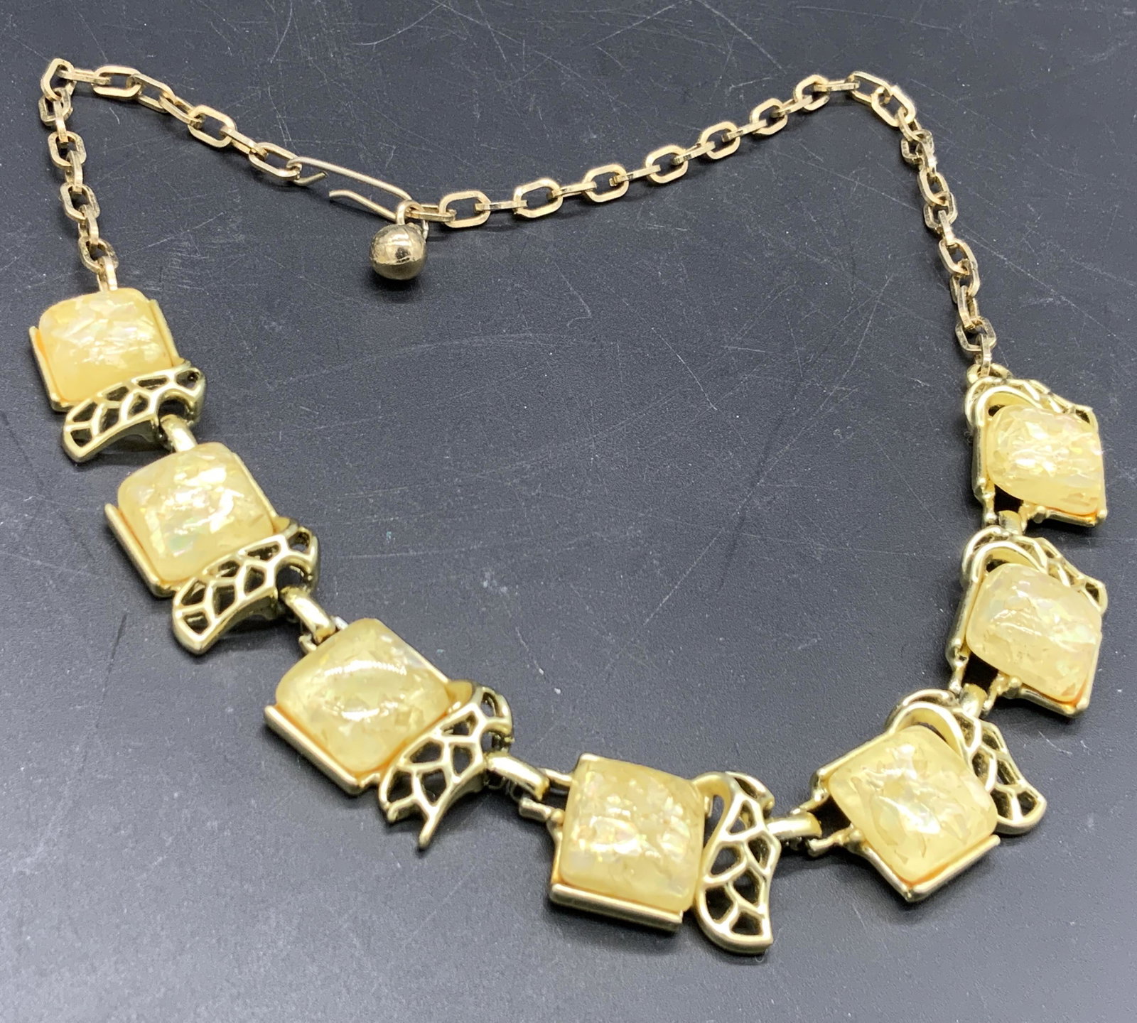 Vtg Iridescent Costume Gem Choker Necklace: A vintage iridescent costume gemstone choker necklace with open metalwork designs. Costume stones are square form and bezel set. Fishhook clasp closure. Necklace length approx 16.5 inches. Surface wea