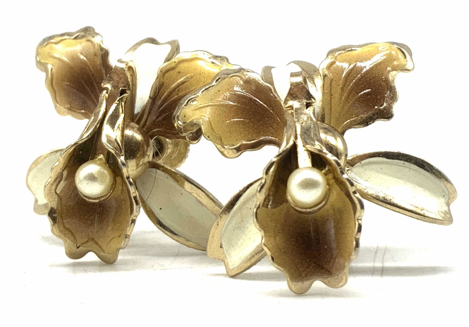 Vintage Floral Enamel Earrings, Jewelry: Floral form gold tone metal earrings with cream & brown enamelwork throughout. Pearlescent bead to the center. Screw on backings. Measures approx 1L x 1W in. Some surface wear present consistent with