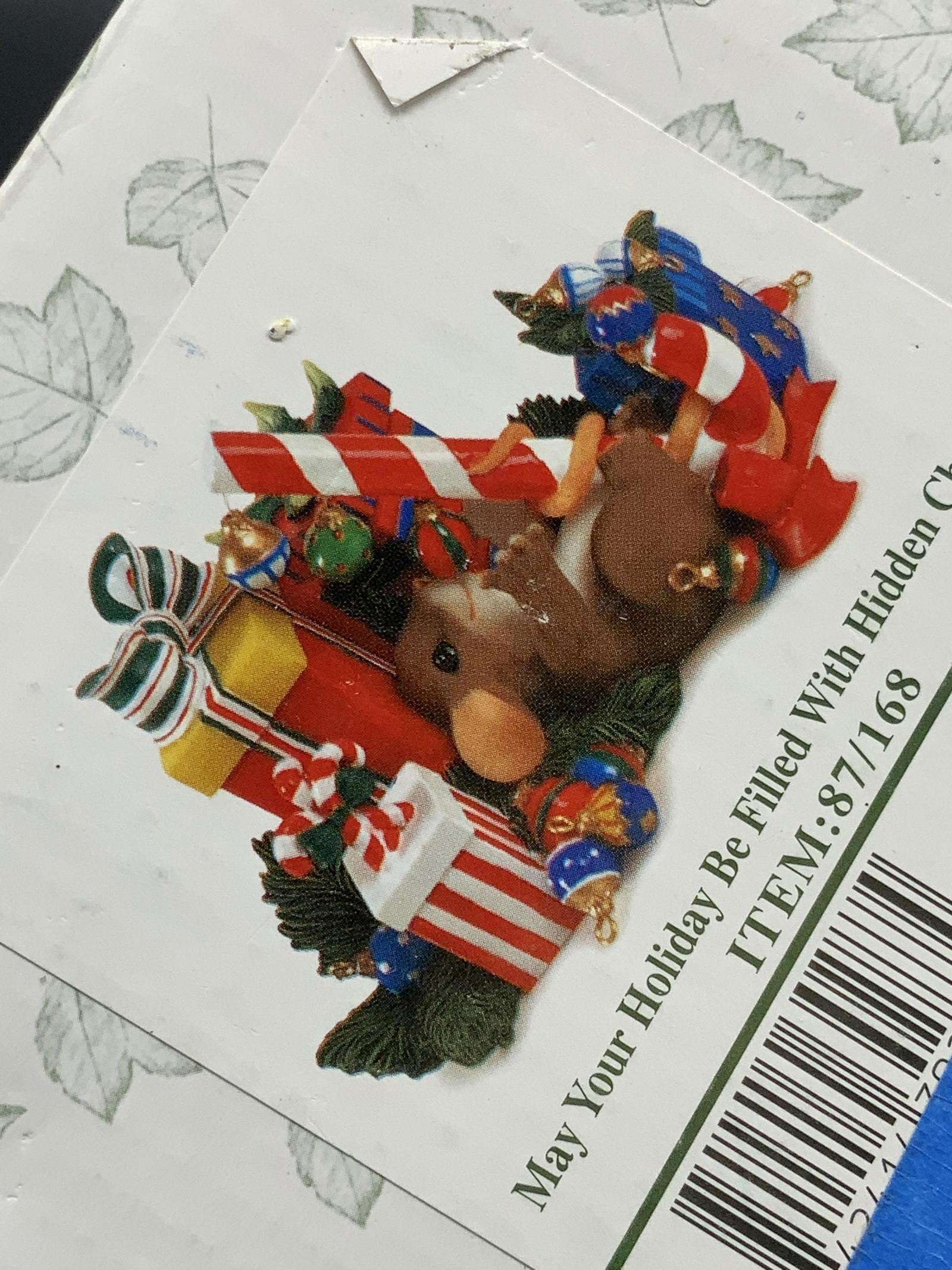 Lot 2 Holiday Ornaments & Decorations, NIP: One box reads CHARMING TAILS by FITZ & FLOYD and contains a MAY YOUR HOLIDAY BE FILLED WITH HIDDEN CHARMS figural. Depicts a mouse with gifts, crafted from ceramic. Piece appears to have never been us