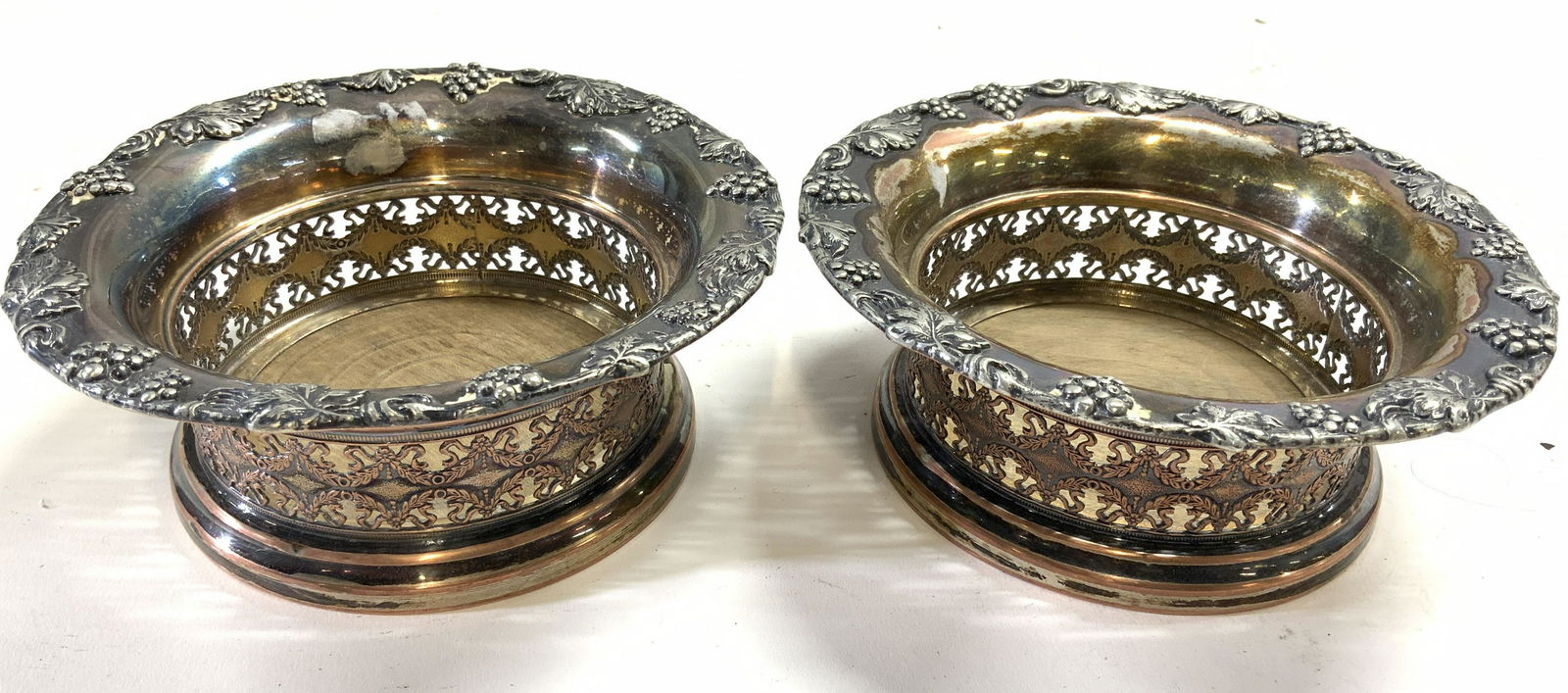 Pair Victorian Style Metal Wine Coasters: Lot includes 2 coasters. Each has ornate detail in addition to grape, vine and leaf detail. Coasters appear to be metal on copper. Each has intricate pierced detail. Coasters measure approx 5.5 inches