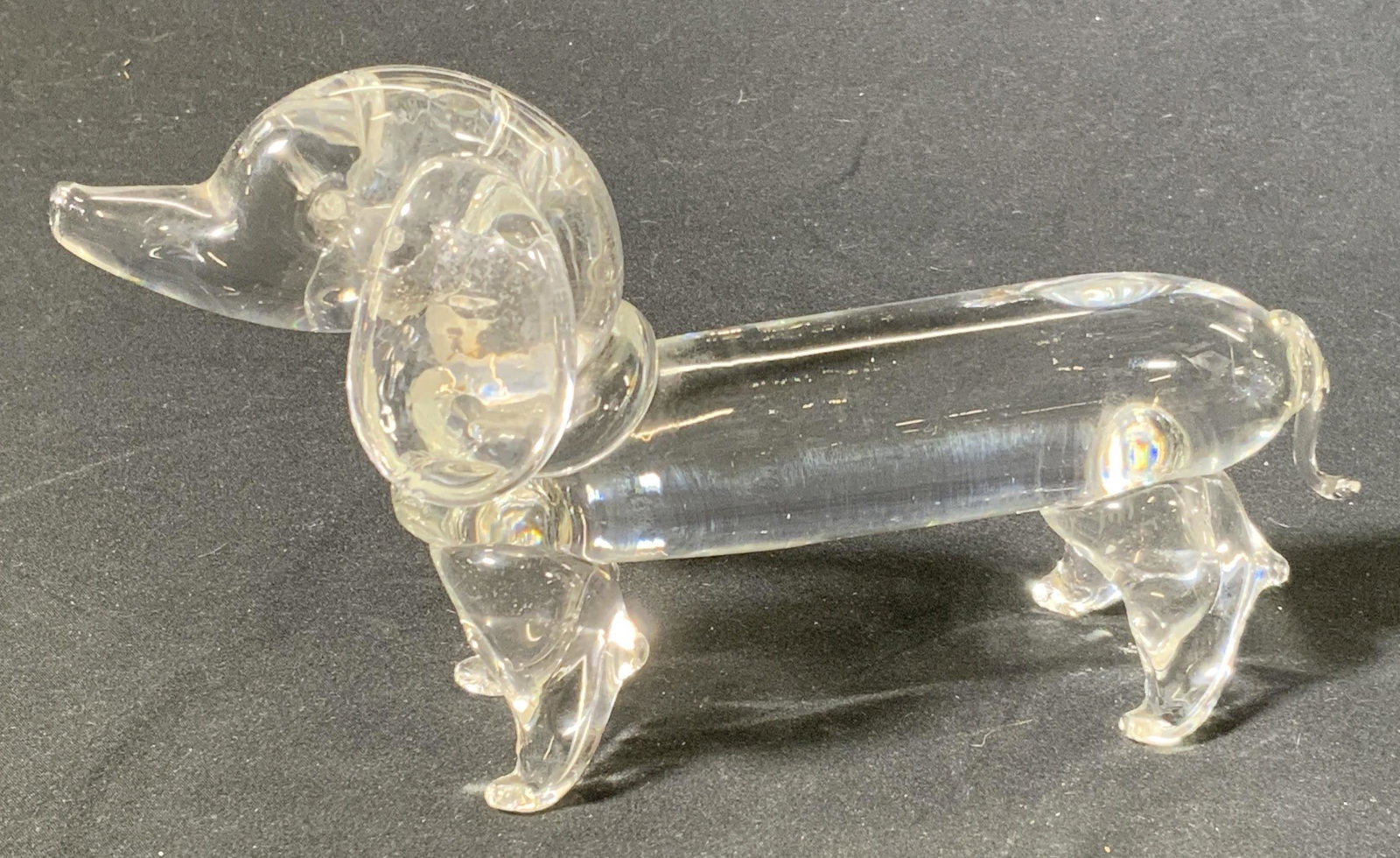 Art Glass Dachshund Figurine: An art glass figurine of a dachshund. In good condition, some surface wear consistent with use and exposure. Measures approx. 8 x 2.75 x 4.5 inches. Property of Palm Beach, Fl Estate. Dachshund figuri