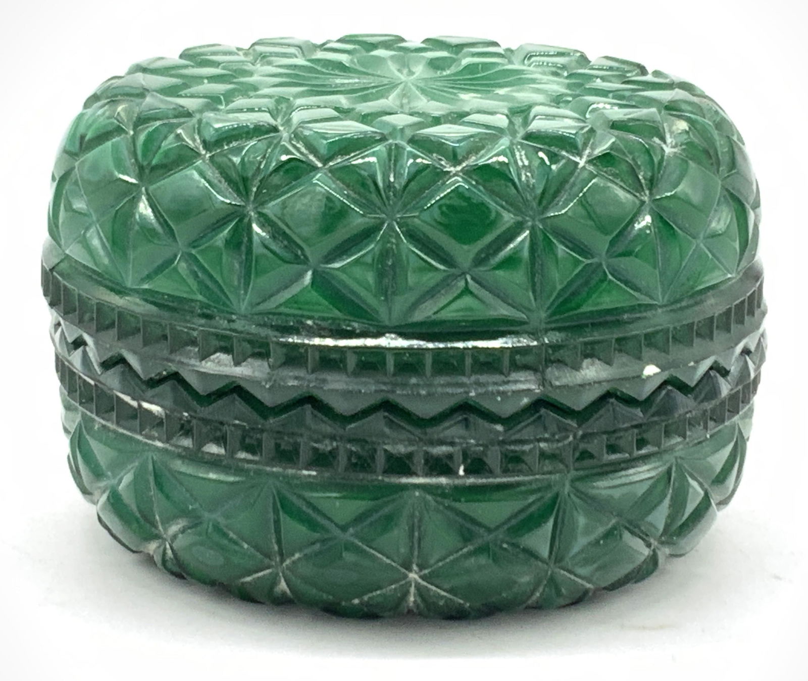 Vintage Malachite Green Geometric Glass Vessel: A vintage malachite green toned glass vessel with saw tooth edges. Each side is cut with diamond shaped patterns. Approximately 2.5 inches tall and 4 inch diameter. Condition is consistent with vintag