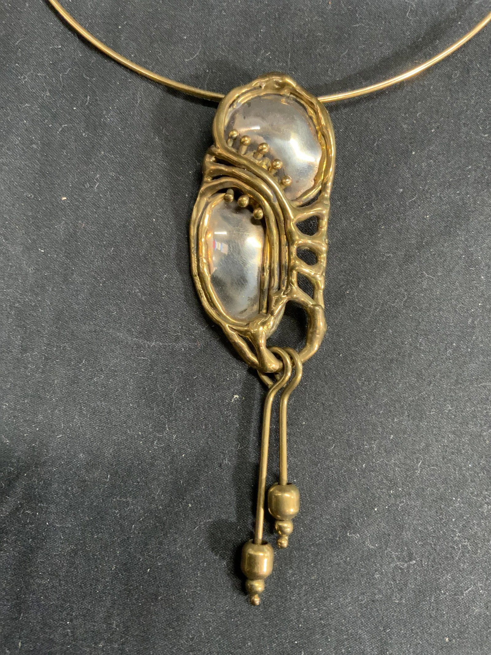 Mixed Metal Sculptural Pendant Choker Necklace: Gold and silver tone sculptural choker necklace with hook clasp. Neck diameter approx. 5 inches. Pendant measures approx. 4.25 x 1.25 inches. Surface wear consistent with exposure. Property of Manhatt