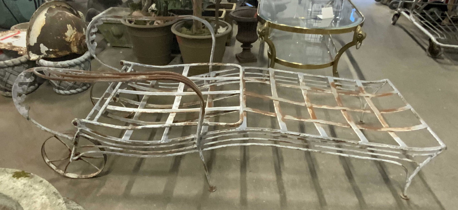 Antique Metal Outdoor Lounge Chair: Lounge chair is vintage possibly antique. Piece is metal. Lounge chair has wheels. Piece has woven structure. Lounge chair measures approx 72 inches long 28 inches wide 34 inches tall at tallest setti