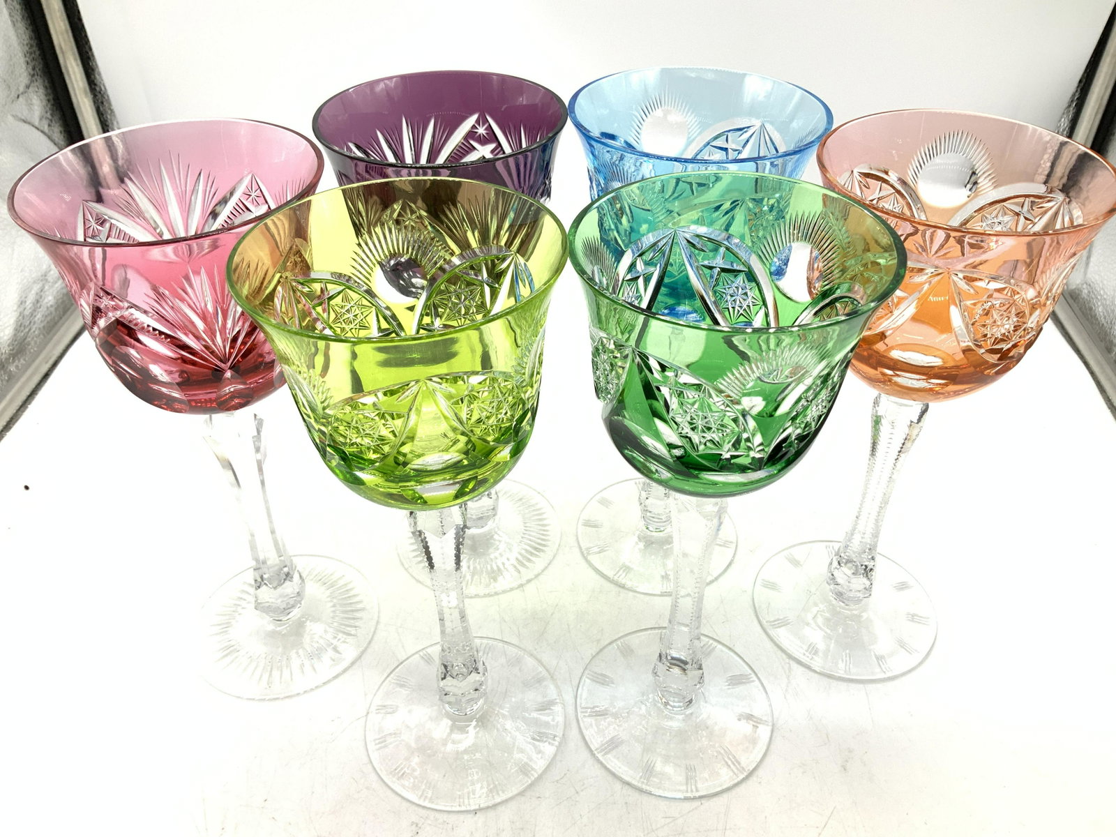 Set 6 Multi Colored Bohemian Glass Stemware: Cut glass goblets, set 4 matching patterns in royal blue, emerald, orange and lime. Pair matching pattern in amethyst and pink. All same shape and size , measure 8.25 x 3.5 in. Vivid colors and facete