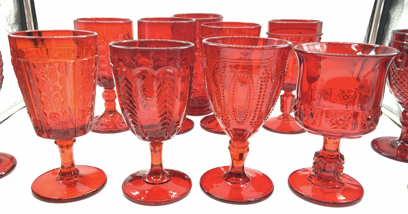 Set 16 Ruby Red Holiday Footed Glass Goblets: Thick walled Ruby red glassware, all with different embossed patterns such as Hobnail, springs , grape bunch, leaves, patterns of lines, stars, flowers, more. Average sizes are 6.75 x 3.5 in. , 6 x 3.