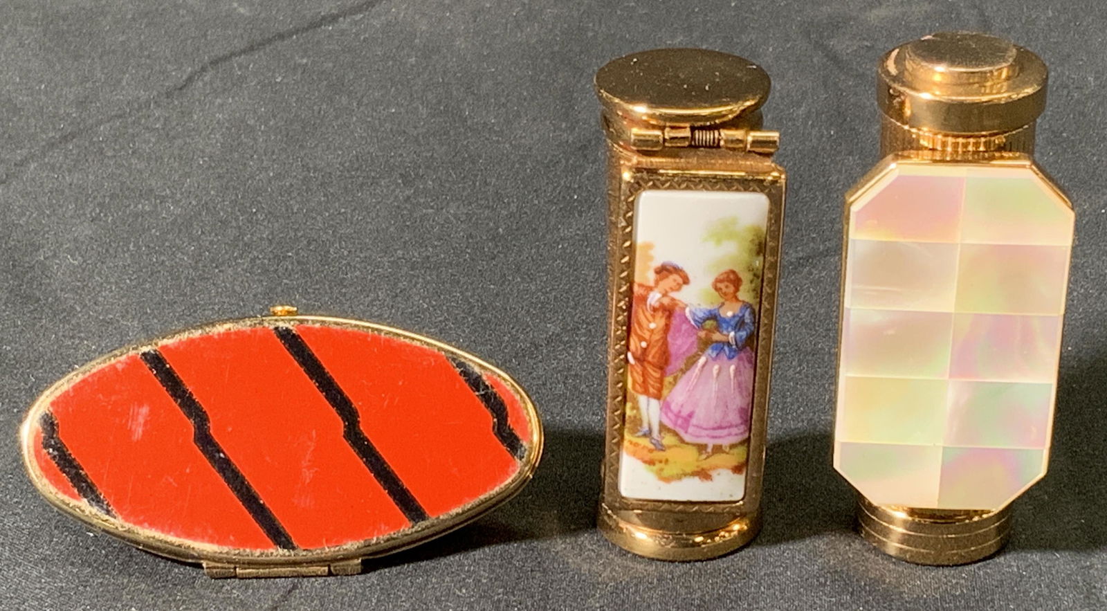 Lot 3 Vintage Lipstick Cases, France & England: 3 vintage gold tone lipstick cases with mirrors. 1 with mother of Pearl decoration and 2 with enameled decoration. 1 marked made in England and 2 marked made in France. Sizes vary, approx. 2.5 inches