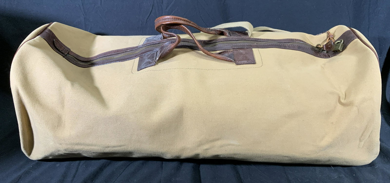 MELVILLE & MOON Canvas Safari Luggage Bag: Melville & Moon beige canvas safari duffel bag. Designer label to interior. 1 zippered pocket to interior. Top zipper closure with padlock and key. Measures approx. 30 x 13 x 11 inches. Gently used. M