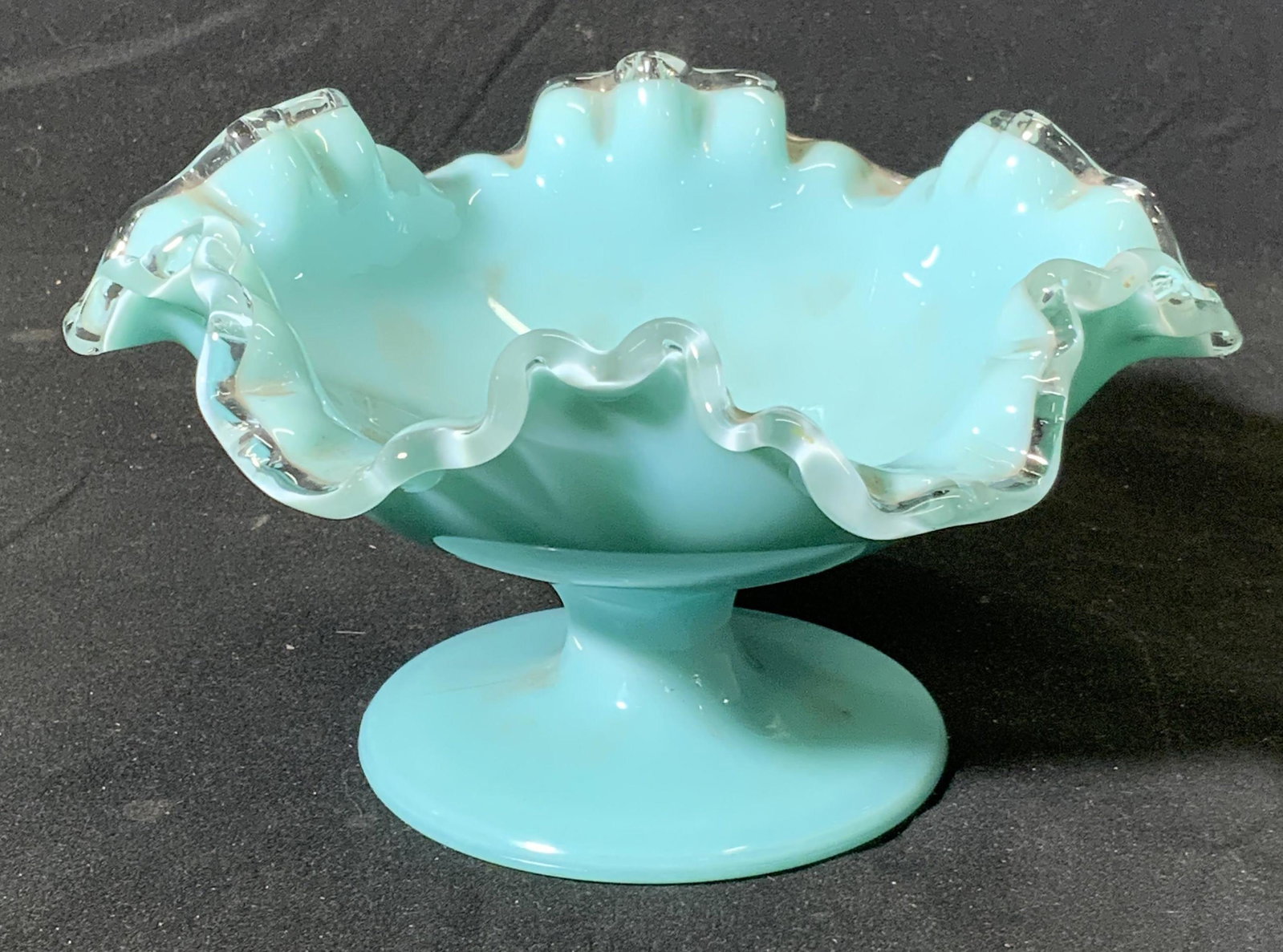 Turquoise Handkerchief Art Glass Dish: Turquoise art glass footed dish with handkerchief rim. Measures approx. 7 inches diameter and 3.5 inches tall. Some wear to surface consistent with exposure. Art glass dish, candy dish, turquoise glas