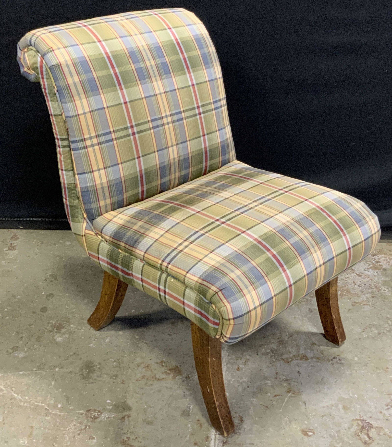 Vintage Upholstered Childs Chair: A vintage upholstered childs chair. Green, blue, and red patterned plaid style upholstery. Soft hand material. Curl to the back. Splayed legs. Underside batting needs repair. Some discoloration presen