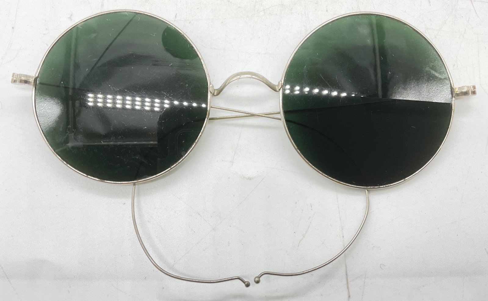 Taw & Co Vintage Round Sunglasses: Vintage , possibly antique, Round Sunglasses. Lens measures Approx 2 inches. Ear piece measures 4 inches. Embossed on nose bridge piece, Taw & Co. Chips to glass present (see photos). Come with a gree