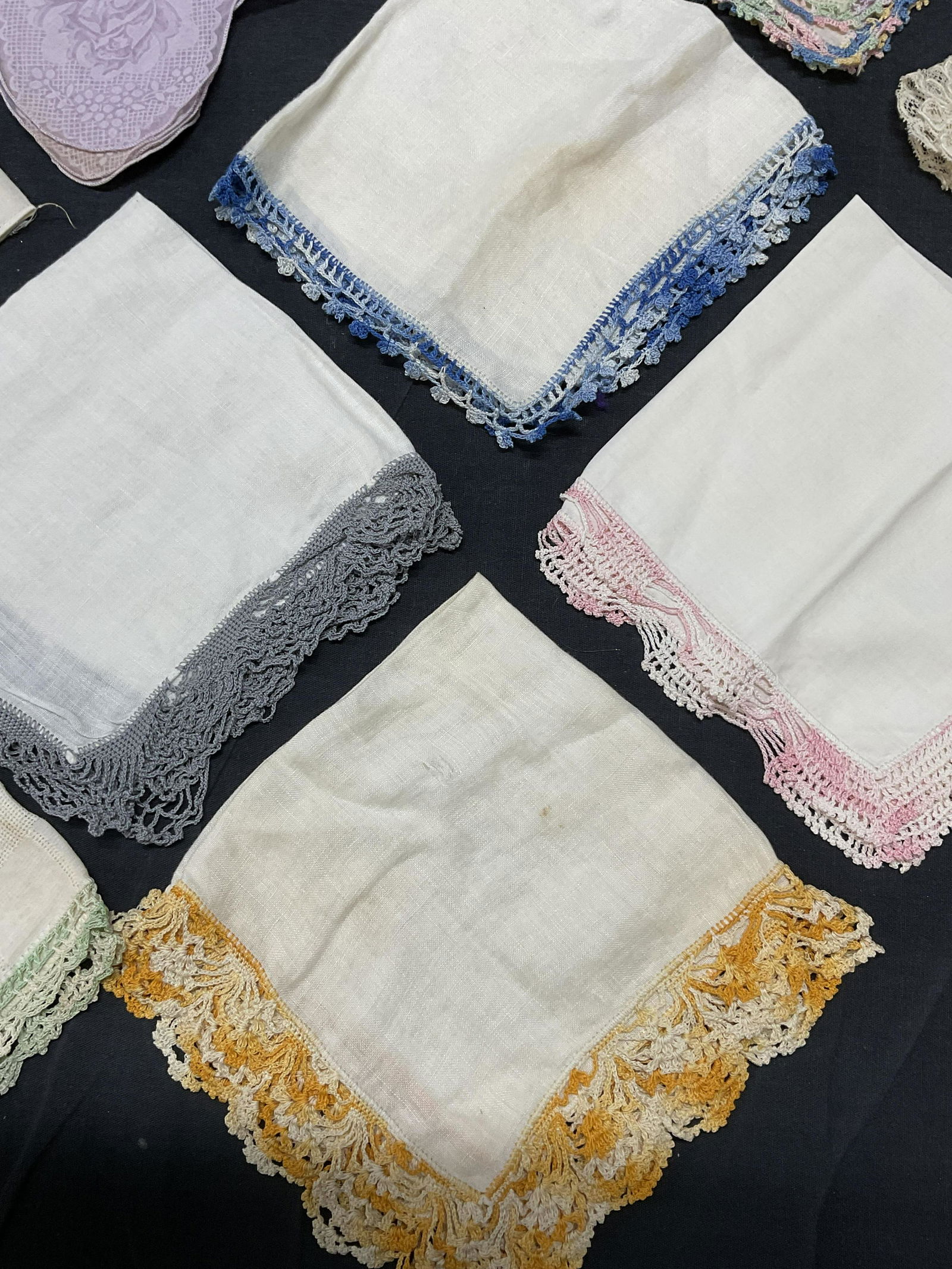 Lot 13 Vintage Lace Detailed Handkerchiefs: Lot 13 possibly Vintage Lace Detailed Handkerchiefs. Significant staining to pieces consistent with age and use. Fabrics lined with colored embroidered colors. 2 pieces used for storing tissues or oth
