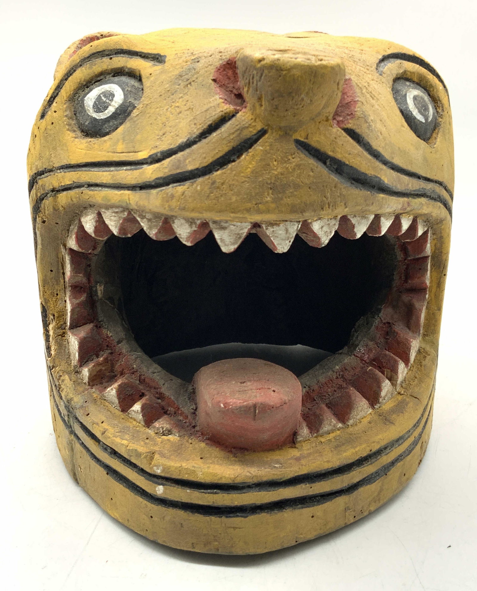 Hand Carved Wooden Folk Art Cat Mask Decor: Hand carved wooden folk art cat mask, painted yellow. Mask has open mouth with carved white painted teeth. Approximately 7.5 inches tall and 6.25 inches wide. Condition is consistent with age and use.
