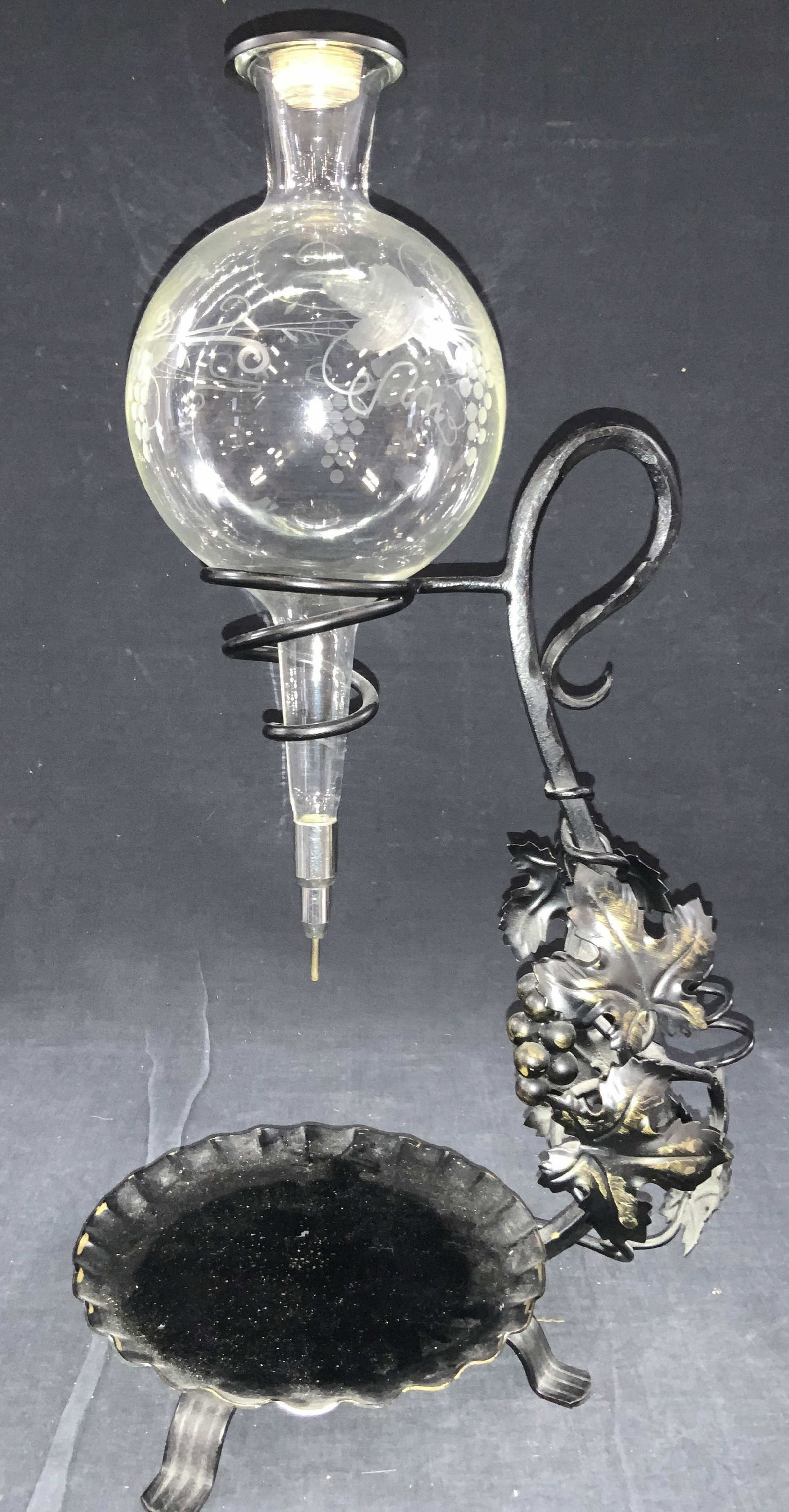 Vintage Ornate Iron W Glass Wine Aerator/ Decanter: Vintage aerator / Decanter. Crafted from painted iron with leaf and grape sculptural elements on stem, base with scalloped edges and four feet. Glass decanter is etched with floral motifs with black c