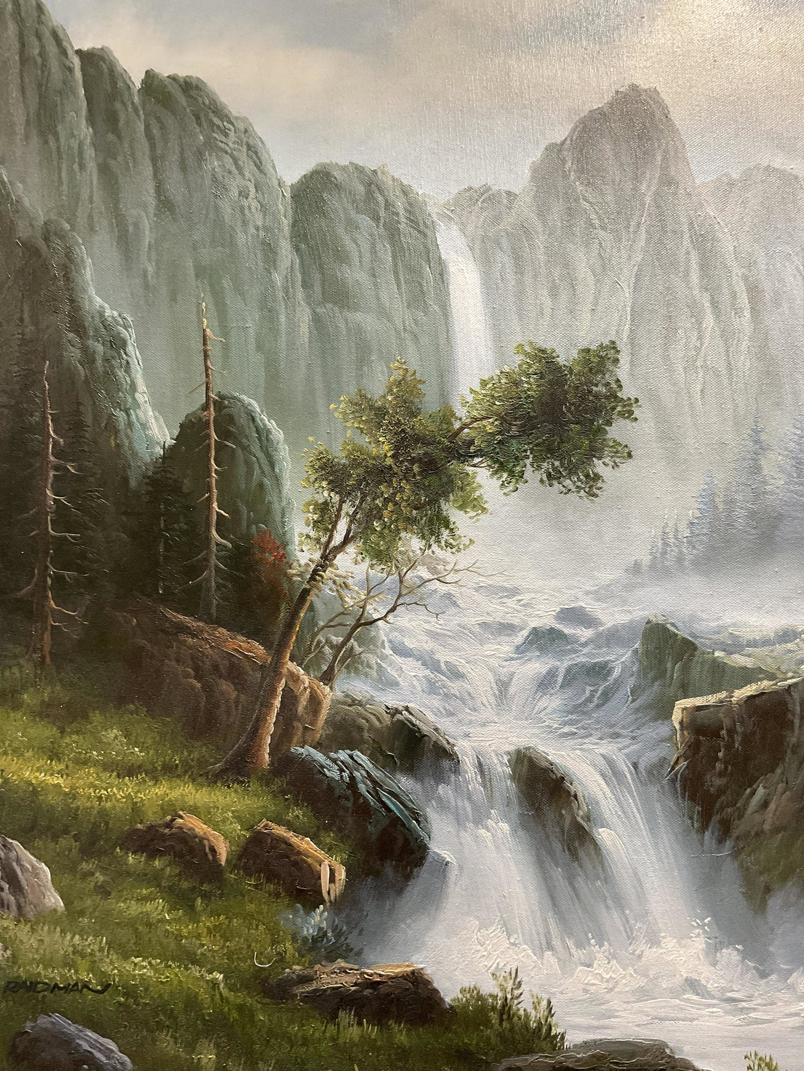 RAIDMAN Signed Oil Painting: RAIDMAN Signed Oil Painting, signature to lower left reads ‘Raidman’, label to reverse reads ‘Bob Kuechenberg’s’, subject a waterfall surrounded by mountains, measures 30 x 25 7/8 inches, wo