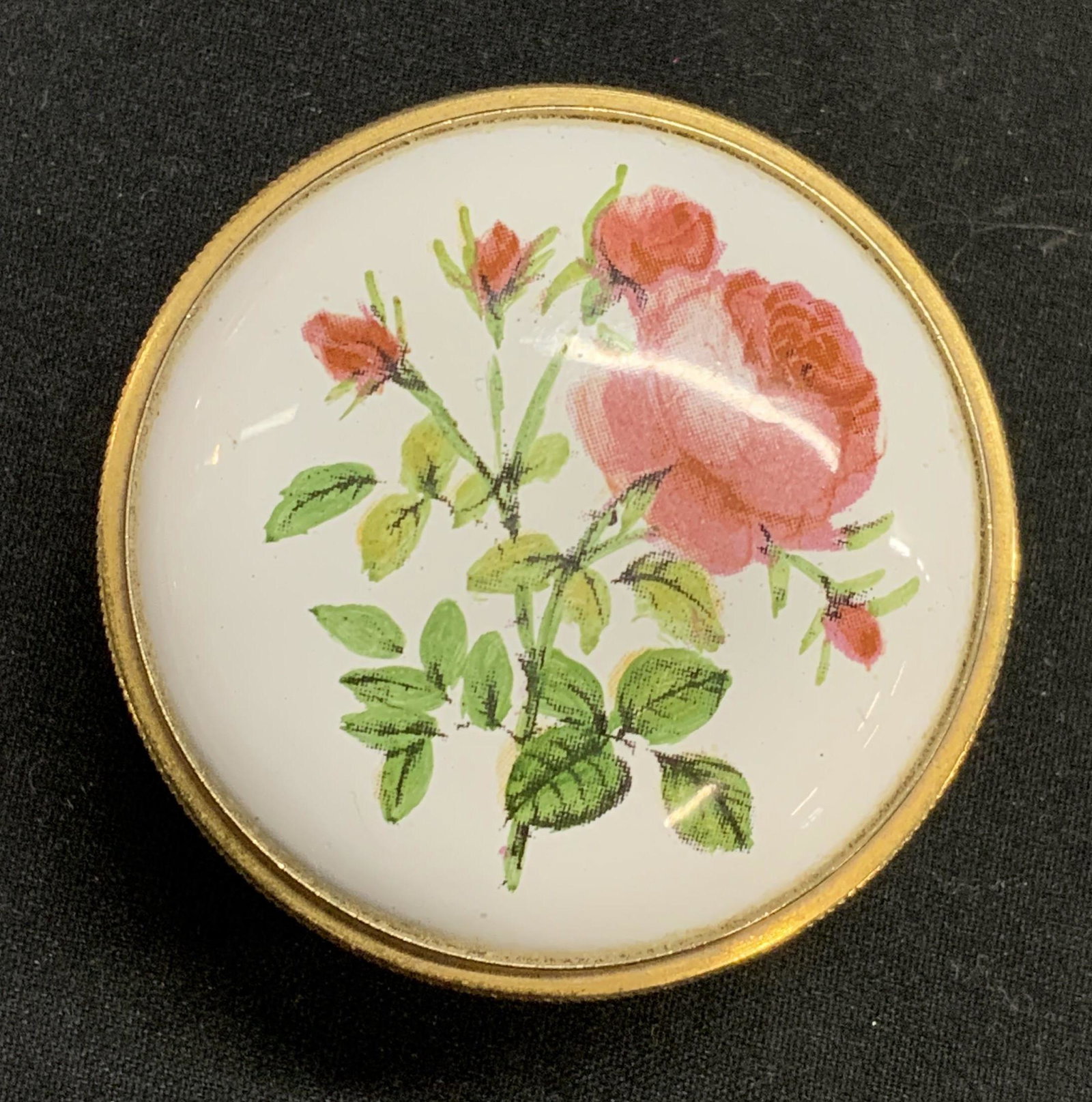 STAFFORDSHIRE ENAMELS Floral Pill Box: Staffordshire Enamels BILSTON BATTERSEA tradition pill box with floral motif. Enamel on metal. Interior reads With the Compliments of British Airways. Measures approx. 1 5/8 inches diameter. Trademark