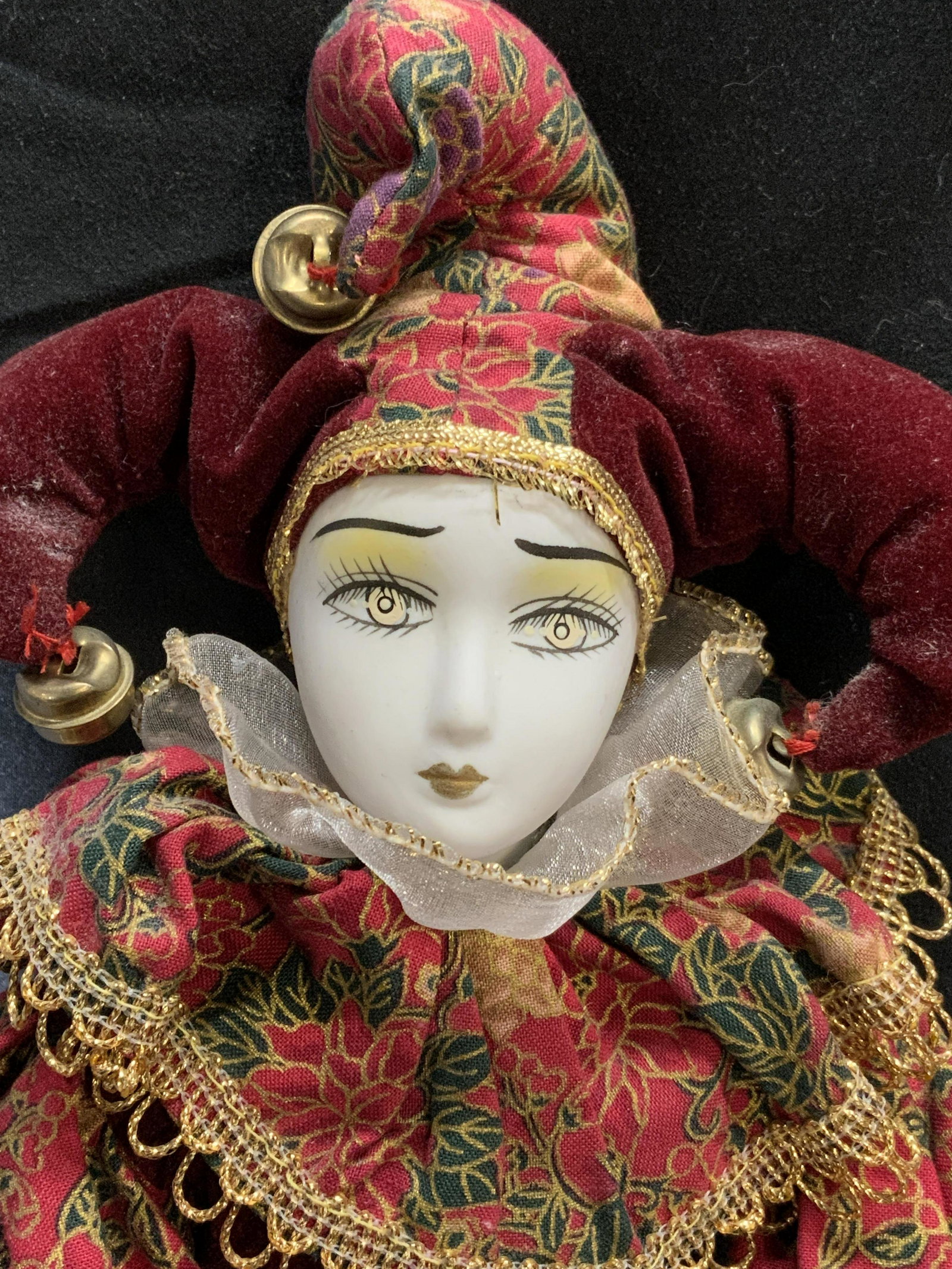 Vintage Harlequin Costume Porcelain Doll: Vintage porcelain doll with harlequin costume. One foot broken. Hand painted porcelain face and limbs and posable fabric and wire body. Measures approx. 16 inches long. Doll, porcelain doll, harlequin