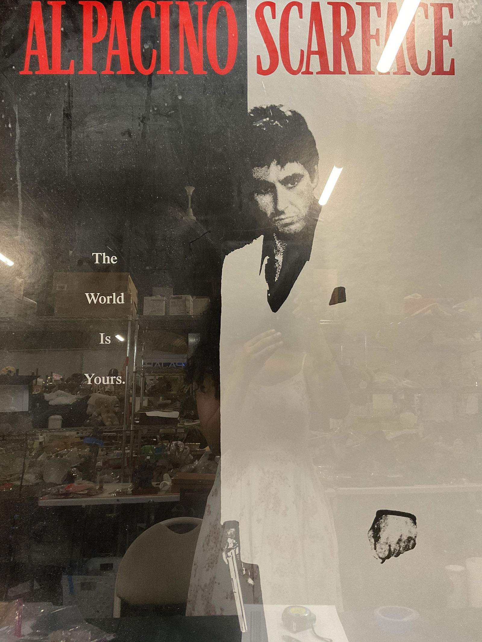 Al Pacino Scarface Movie Poster: Al Pacino Scarface Movie Poster, inscriptions read Al Pacino Scarface, The world is yours, label to reverse reads Jacks Art Gallery, subject a man holding a gun, measures 41 1/4 x 28 1/8 inches, red w