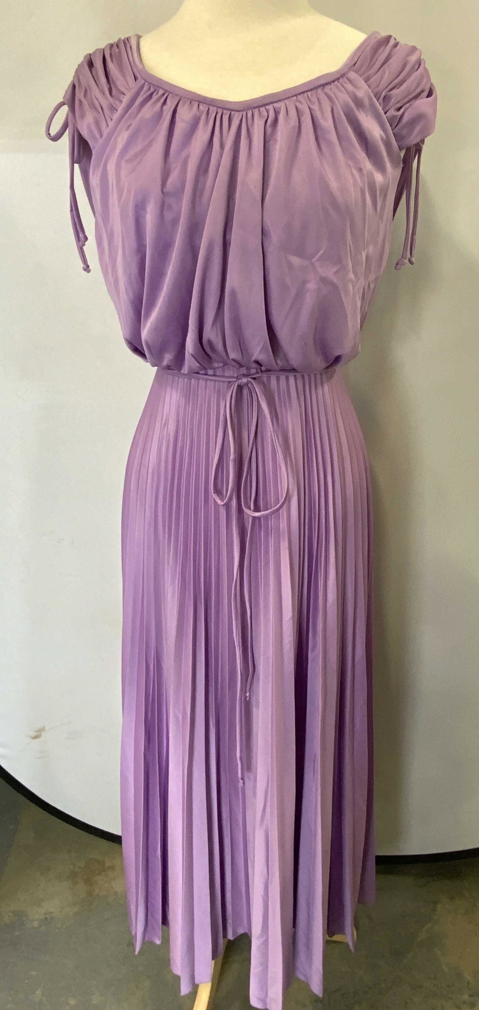 Vintage Lilac Pleated Maxi Dress: A vintage maxi dress with pleated skirt, tie waist and drawstring cap sleeves. Vintage size 10. Possibly synthetic blend. Fabric has some stretch. Gently worn, some wear to lower hem consistent with u