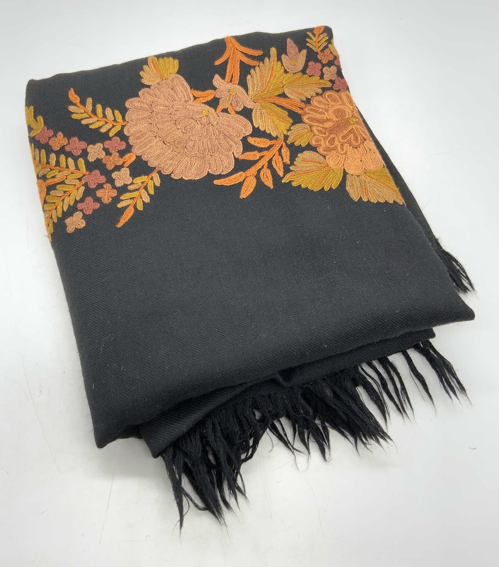 Vintage Black Floral Embroidered Fringe Trim Scarf: A black scarf with fringe trim. Floral and foliage embroidery to piece. Muted fall hues. Orange, red, green hues throughout the florals. Measures approx 72L x 27W in. Some wear consistent with age and