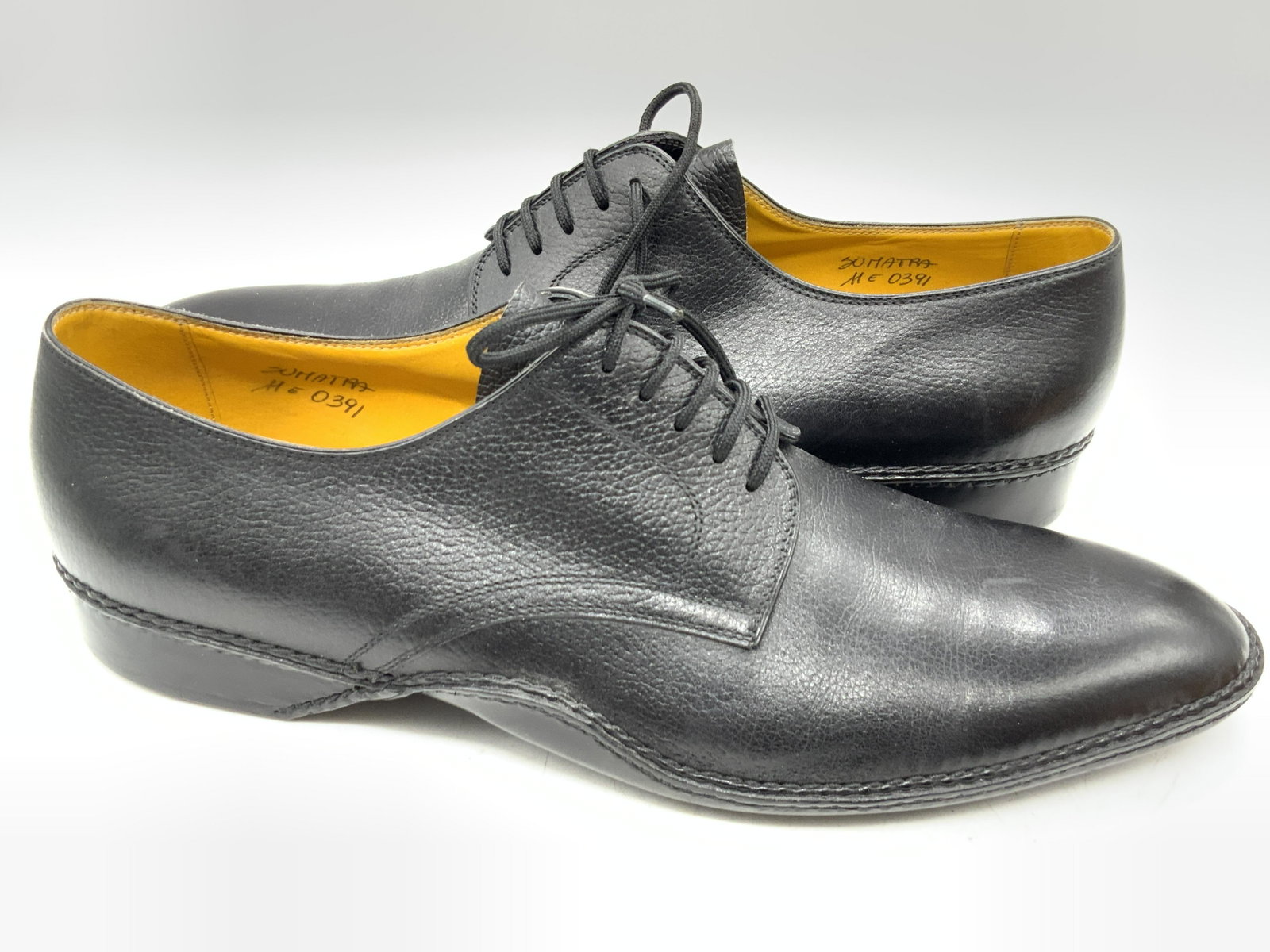 JOHN LOBB Black Leather Lace Up Shoes: Black leather lace up shoes. Interior is yellow hued and marked JOHN LOBB. Underside marked JOHN LOBB 11. Interior side marked SUMATRA ME 0391. Some surface wear consistent with use and storage. Weara