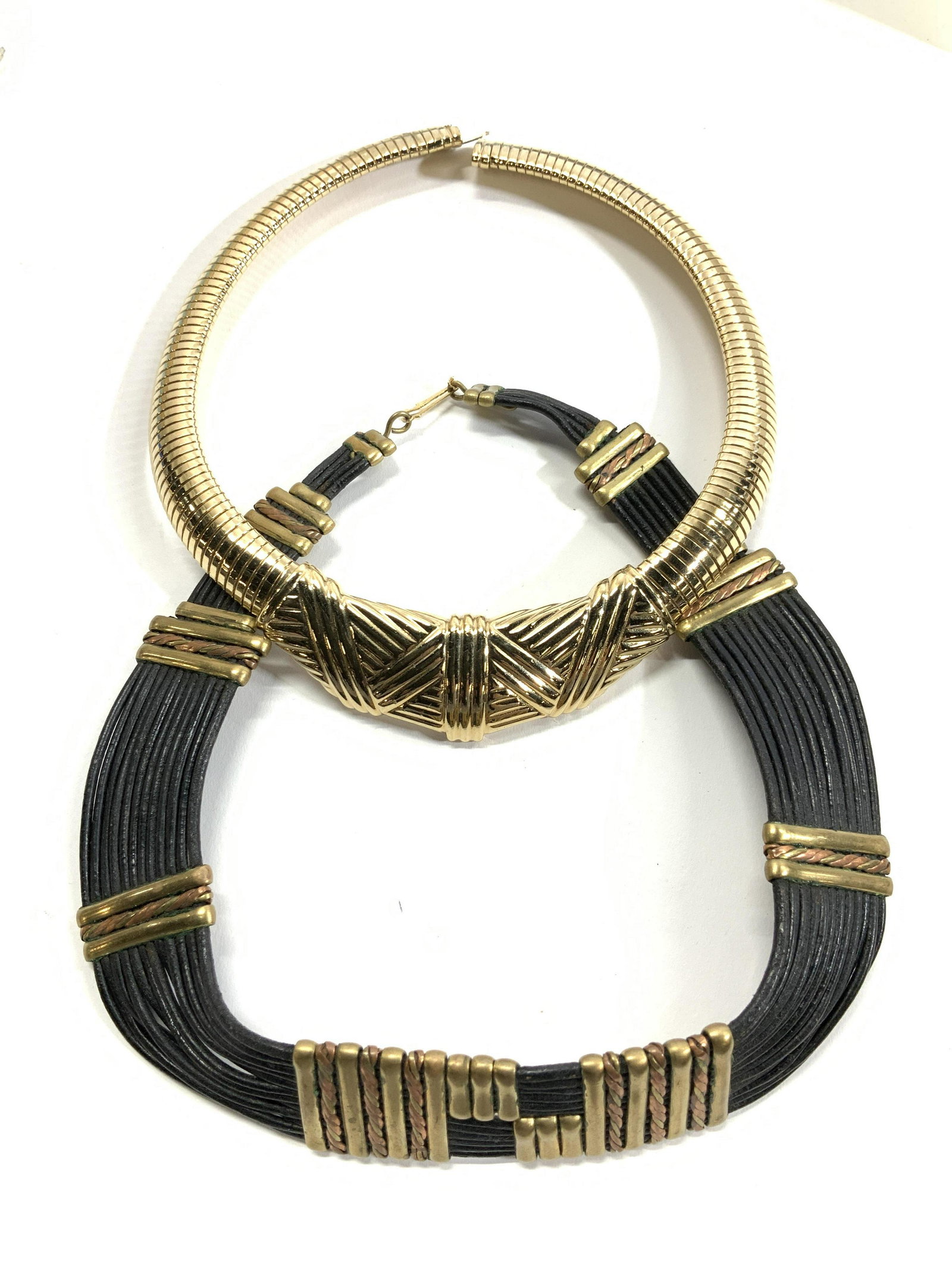 2 Choker Necklaces, Gallery Original: Black cord choker necklace with brass and copper toned metal accents, measures 1 in wide, 15.5 in long. Hook and loop clasp. Gold tone stretch GALLERY ORIGINAL choker necklace, 1 in at widest, 16.5 in