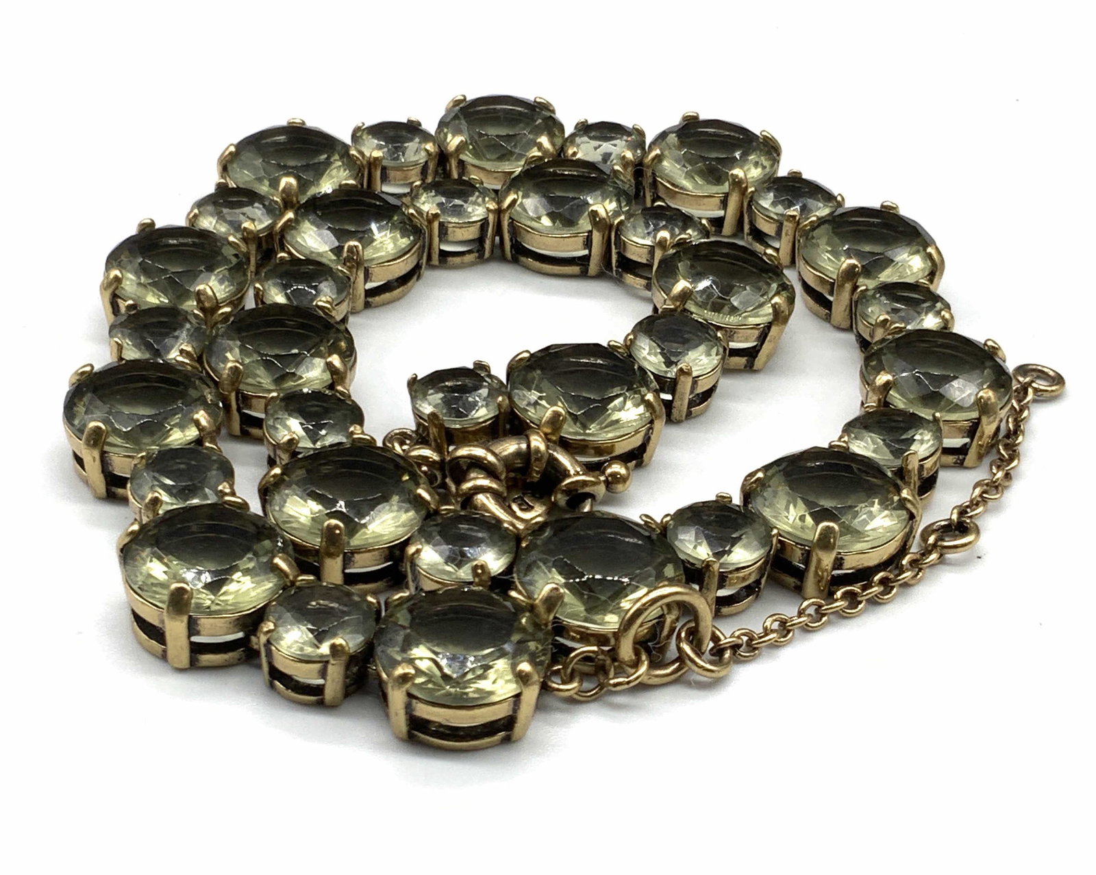 J. CREW Bejeweled Faceted Crystal Necklace: A light smokey green hued crystal necklace. Gold tone metal hardware. C spring style clasp closure. Charm adjacent to clasp closure reads J. CREW. Measures approx 20 inches. Necklace has some weight t