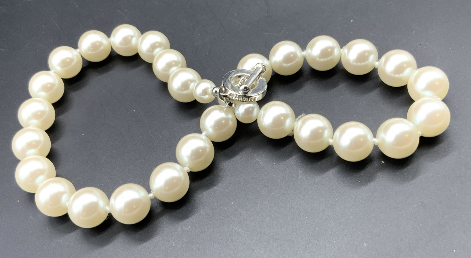 CAROLEE Vintage Pearlescent Choker Necklace: A vintage pearlescent beaded necklace with a silver tone metal toggle clasp. Clasp stamped CAROLEE. Measures approx 16 inches in length. Some surface wear consistent with use and age. Vintage jewelry,