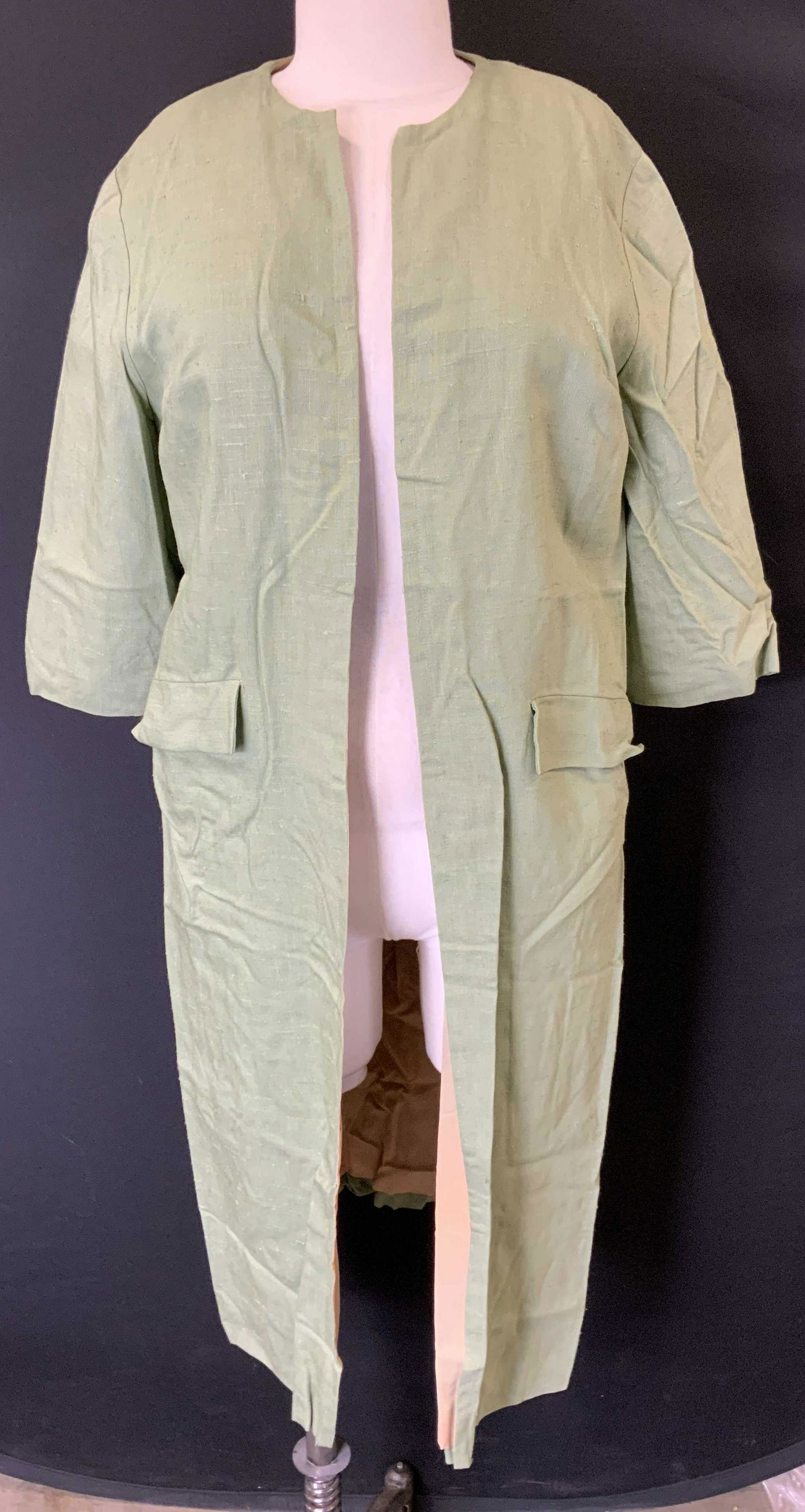 Vintage 1950s Green Linen Coat: Vintage mid century green linen coat with yellow polyester lining. Half sleeve, open body, front pockets. Pulling and pilling to fabric present. Measures approx. 21 inches across chest. Vintage fashio