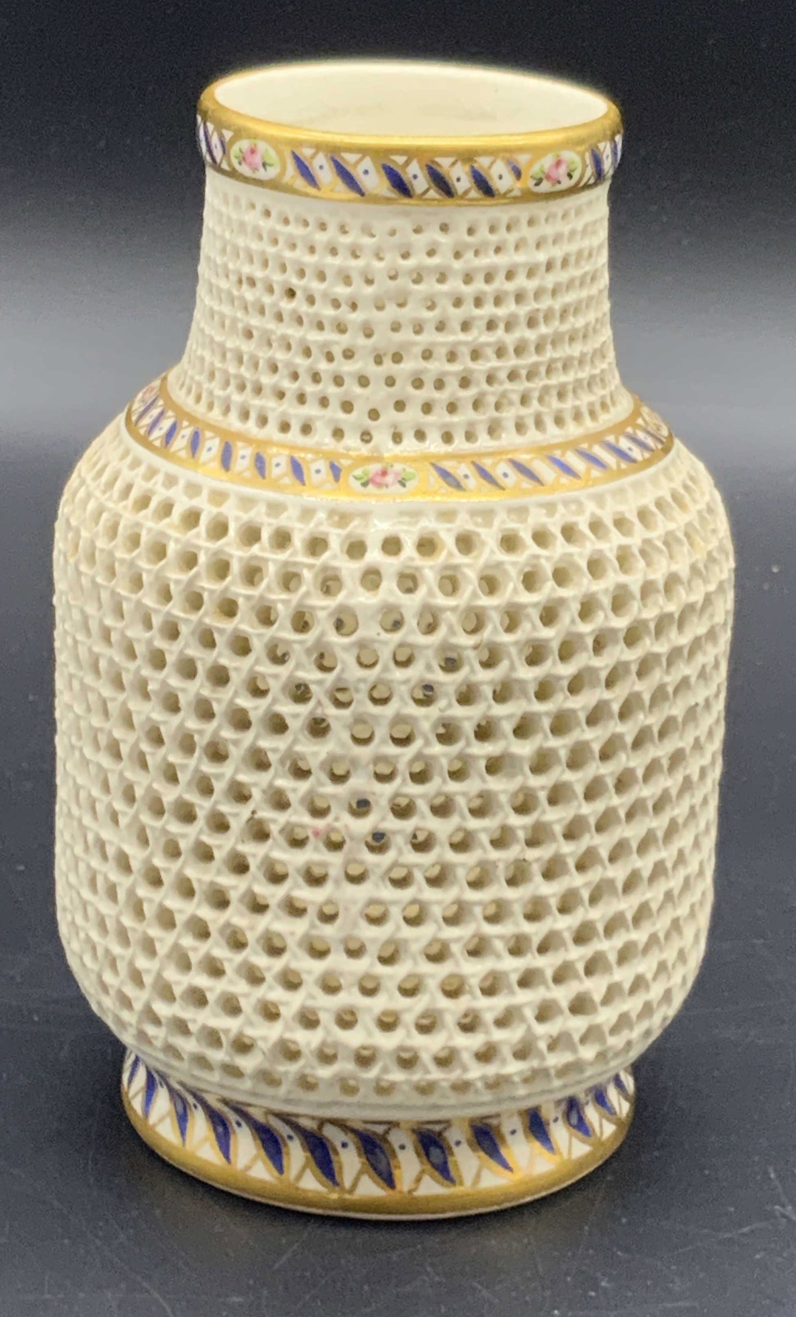 Trademarked Hungarian Hand Painted Porcelain Vase: A vintage hand painted Hungarian pierced porcelain vase. Gilt, cobalt, and pink florals accent the piece. Underside is trademarked, trademark and brand name are worn, illegible. Underside reads MADE I